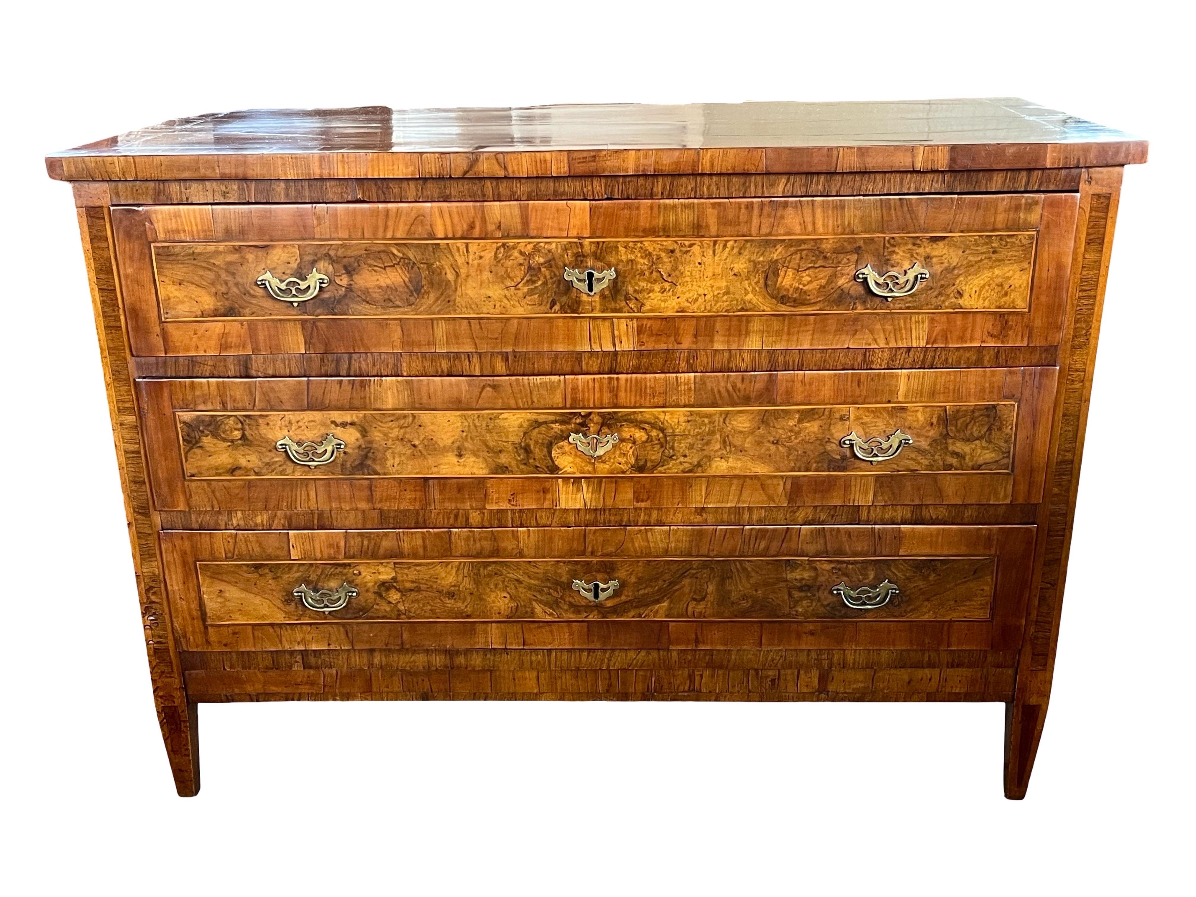 Neoclassical commode hand-made in Italy in the late 1700s using walnut and decorated with walnut veneer. This is an absolutely stunning chest of drawers both because of its lines and color and because of the perfect placement of veneer of different