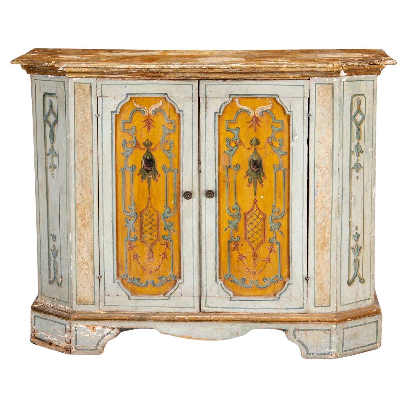 L'armoire décorée néoclassique italienne du XVIIIe siècle est peinte à la main et présente des motifs néoclassiques magnifiquement rendus - guirlandes, volutes, urnes et éléments feuillus. Les doubles portes centrales, ornées de panneaux de style