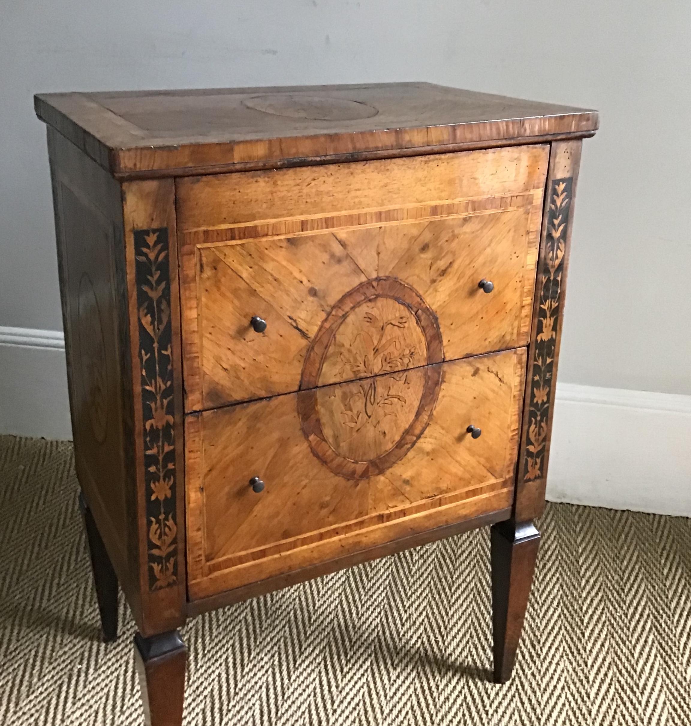 18th century Italian walnut commodino with circular foliate marquetry panels to the top front and sides and crossbanded throughout in tulipwood with black and satinwood inlaid pilasters to front and sides and tapering shaped supports. This commodino