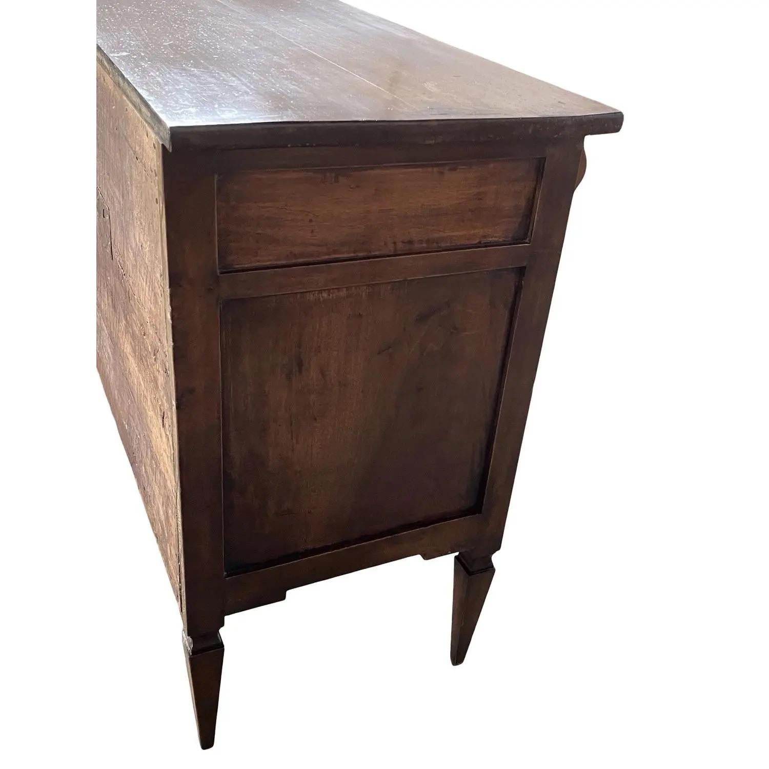 Cassettone realizzato a mano in Italia alla fine del 1700 con legno di noce e struttura a pioli. Il comò ha una linea molto lineare e presenta tre cassetti incassati con frontali piatti. I lati sono costituiti da pannelli piatti e incastonati,