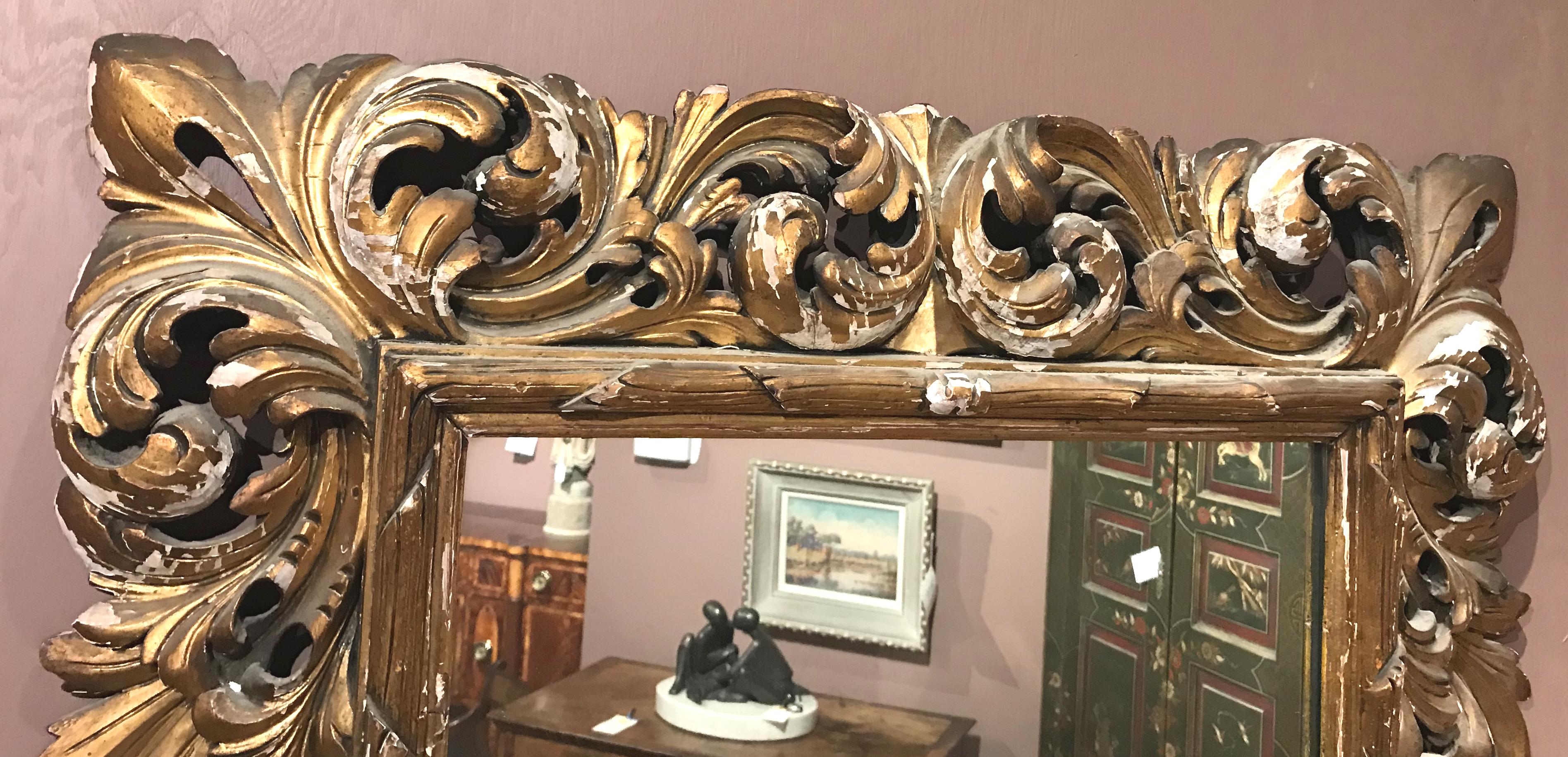 A fine example of an 18th-19th century Italian pierce carved giltwood framed mirror with scrolled foliate decoration, with some gilt losses overall and other imperfections and expected wear from age and use. The glass has been replaced at some time.
