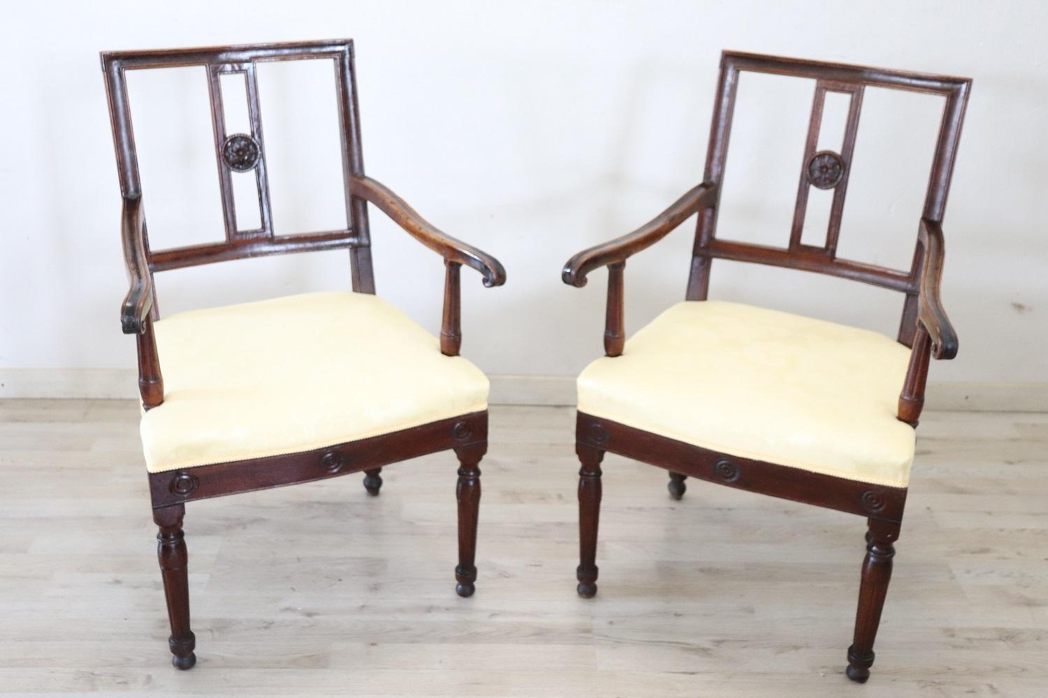 Lovely Italian antique armchairs, set of 2, 1750. These armchairs are of the period Louis XVI in solid walnut wood. The seat upholstered in fabric. Beautiful simple line. This beautiful armchairs has an enveloping shape and a comfortable seat. Good