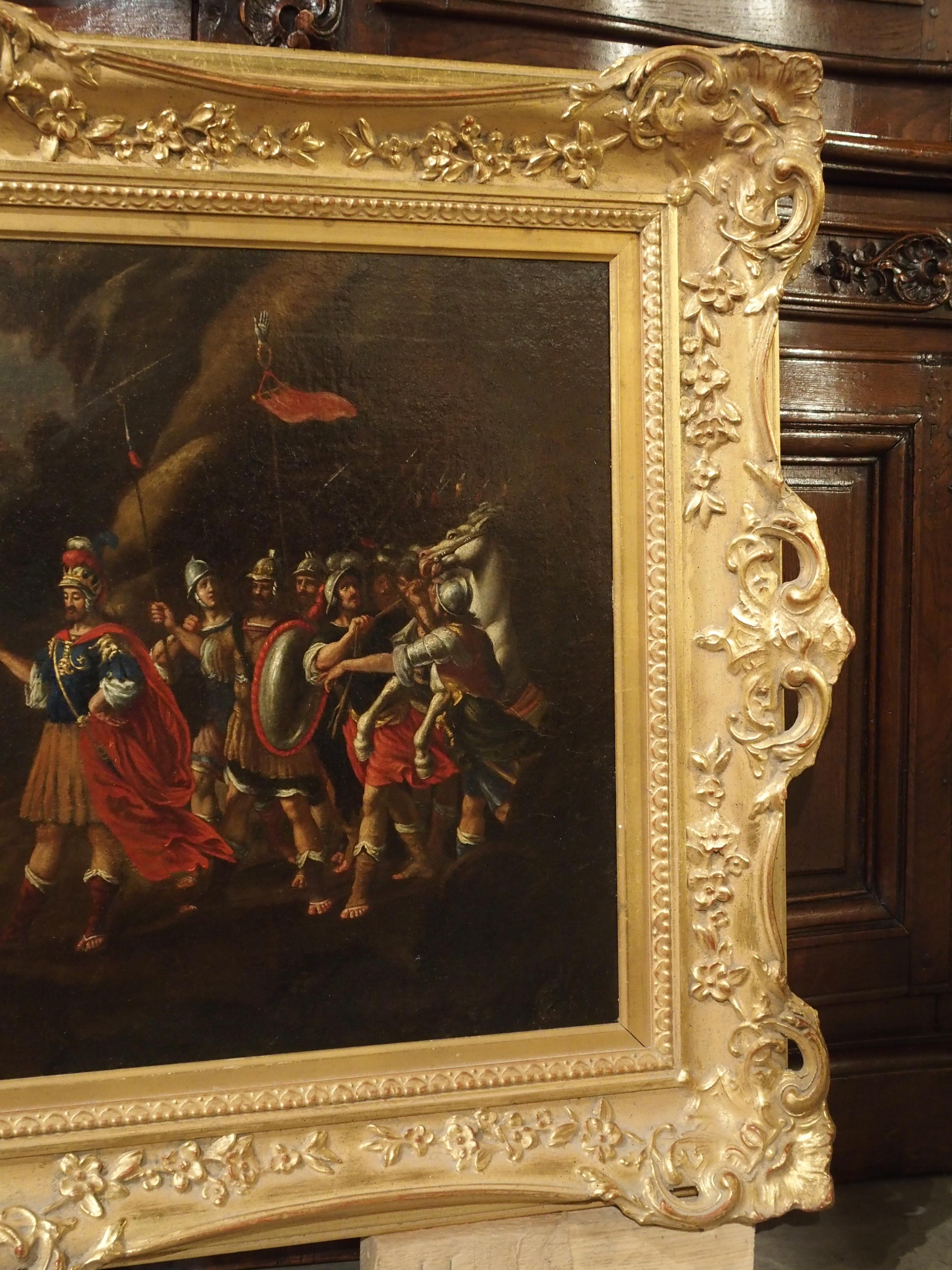 The rectangular oil painting measures nearly 4 1/2 long at the edges of the frame. It is of the Italian school during the 1700s, though the beautiful giltwood frame is 20th century. The scene is a depiction of a brightly dressed European army