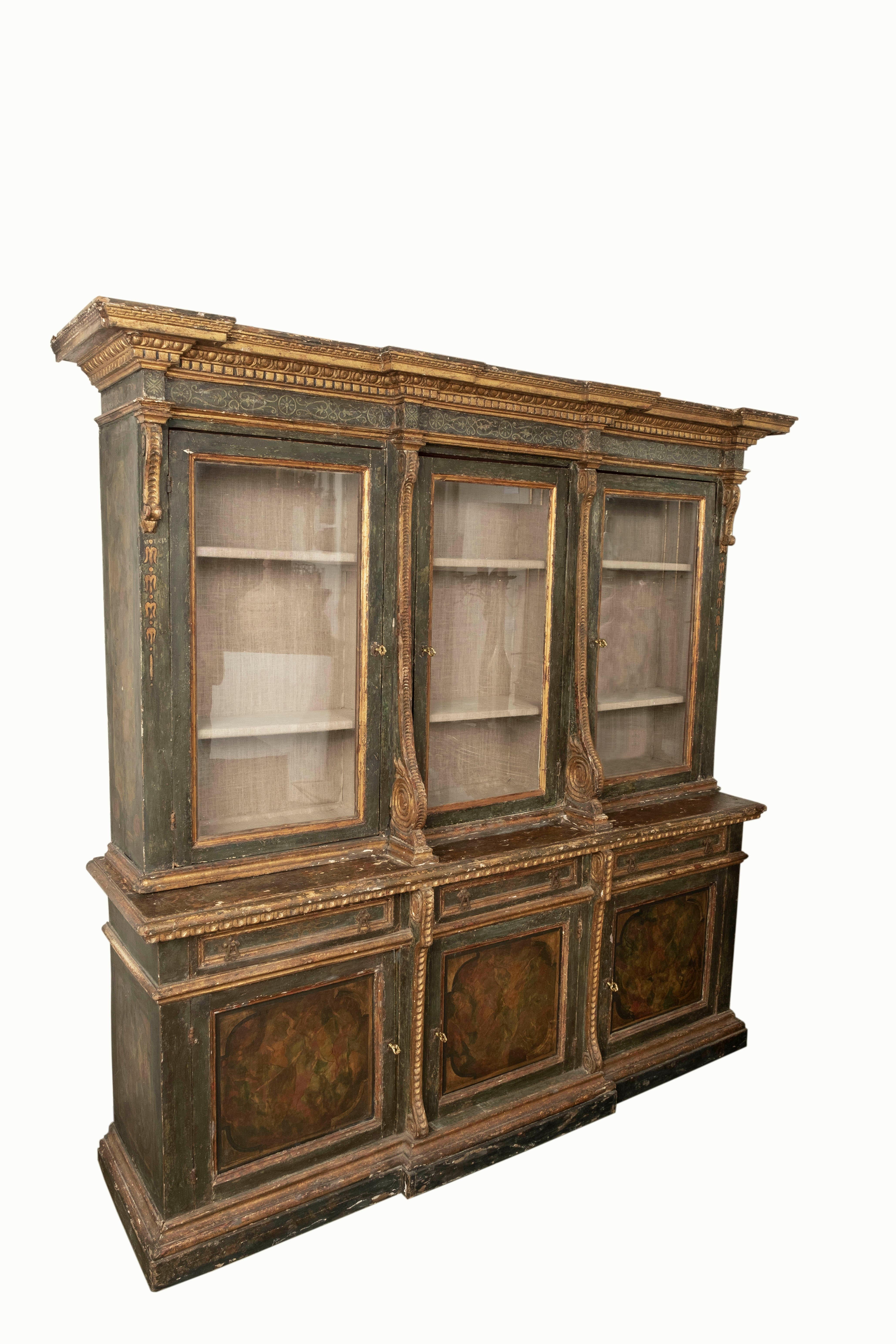 Italian Bookcase, 18th Century Painted And Parcel Gilt.
This stunning 18th century Baroque painted and parcel gilt bookcase has 3 glass cabinet doors above for display, 3 drawers below and 3 wood cabinet doors at the bottom for storage.
The paint