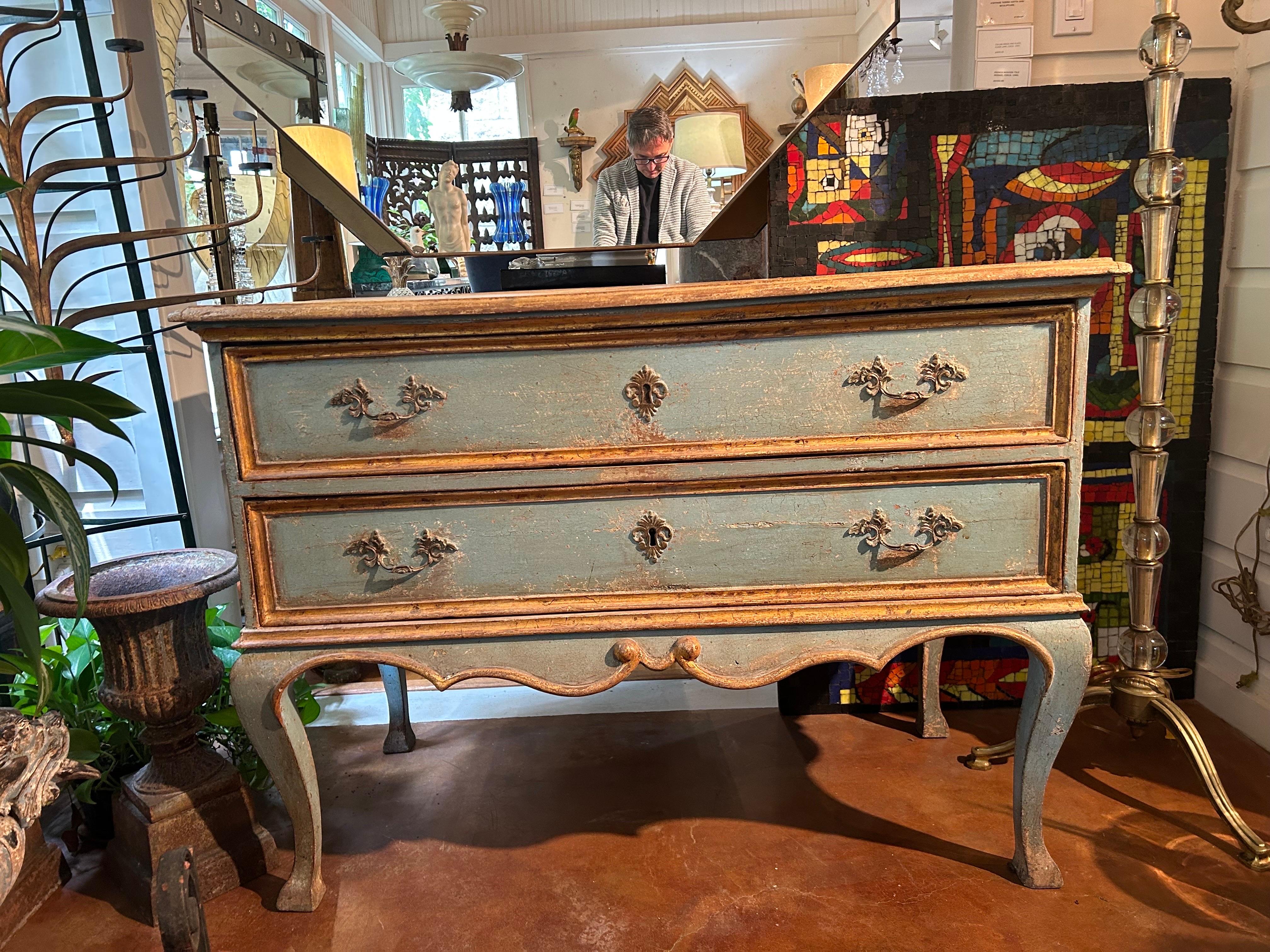18th Century Italian Painted Chest Or Commode.
Stunning 18th century Italian painted commode or chest with gilt accents from the Tuscany region of Italy. This lovely 2 drawer chest is painted a beautiful shade of blue with a parcel gilt trim and a