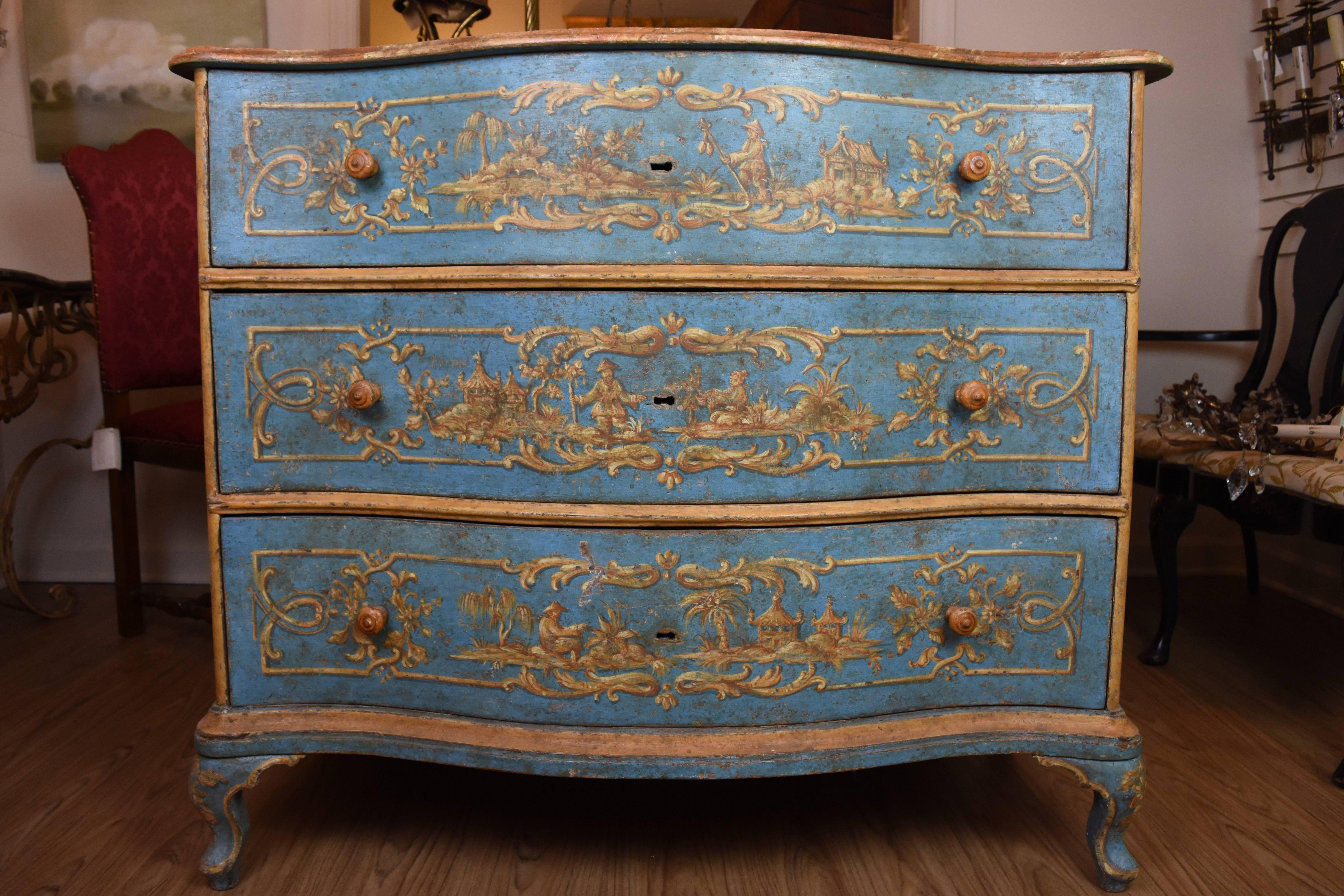 This exquisite 18th century Italian commode features a serpentine front with three functional drawers all hand-painted with chinoiserie decoration. The base color of the commode is blue with the top a faux marble design in shades of terracotta, gold