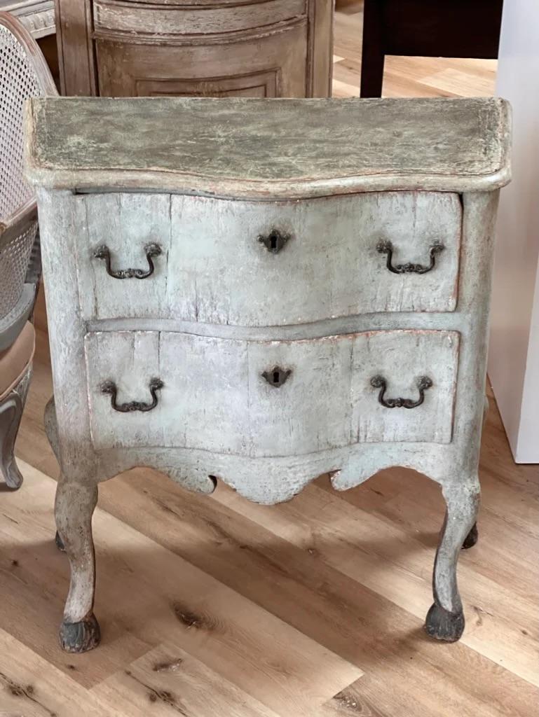 Italian Painted small Commode, Venice, early 18th century, of serpentine form, the shaped top with molded edge over two drawers, above shaped apron, raised on cabriole legs with stylized hoof feet, ht. 34 1/2, wd. 32 1/4, dp. 15 3/5 in
