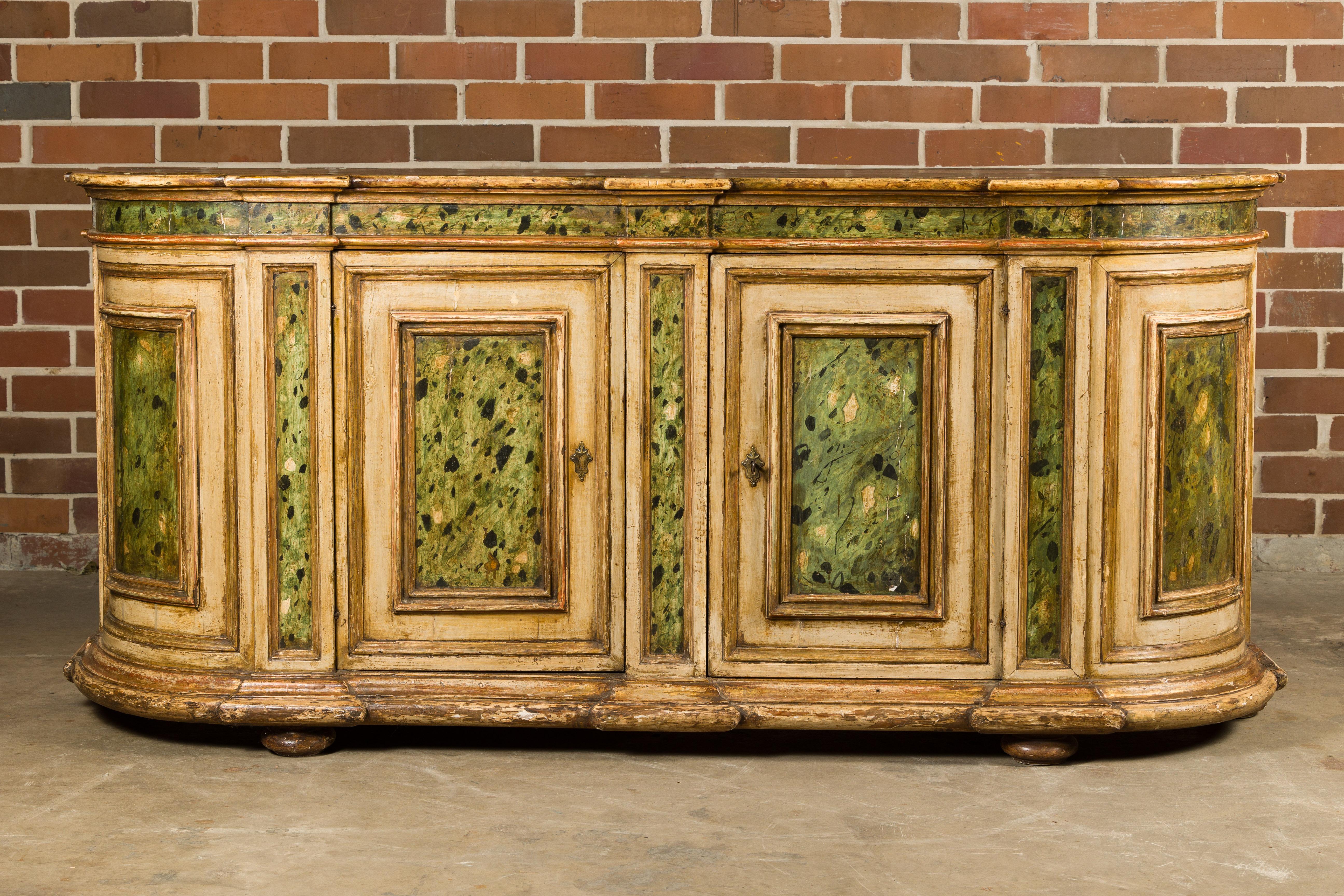 An Italian painted wood sideboard from the 18th century with two doors and rounded sides. This 18th-century Italian painted wood sideboard is a captivating piece that encapsulates the elegance of its era. Its classic design features two gracefully