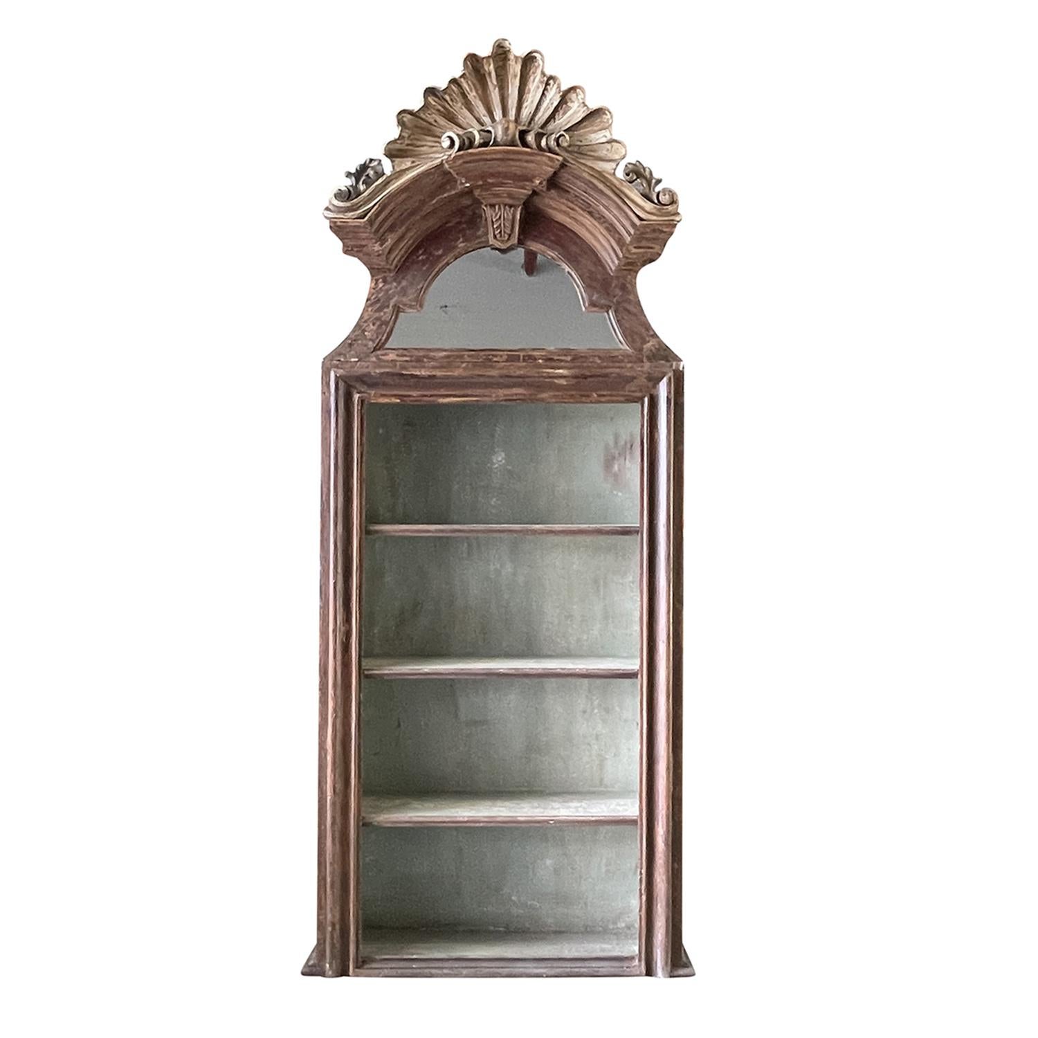 Pareja de antiguas bibliotecas o estanterías barrocas italianas de principios del siglo XVIII, de madera de pino trabajada a mano con una pátina moteada de color burdeos desgastada, en buen estado. El interior de los armarios tiene un acabado