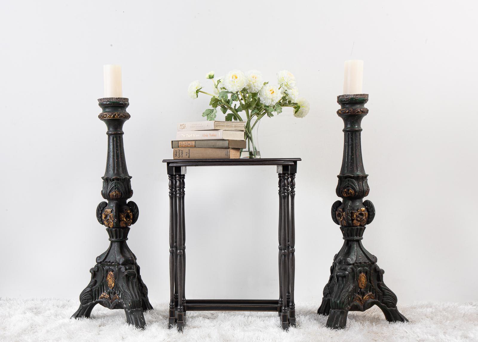 Pair of monumental 18th century Italian prickets made in the Rococo style of carved and polychromed wood. These altar candlesticks feature a three footed base and a floral motif with gilt highlights and original pie crust tops. Finished in a rich,