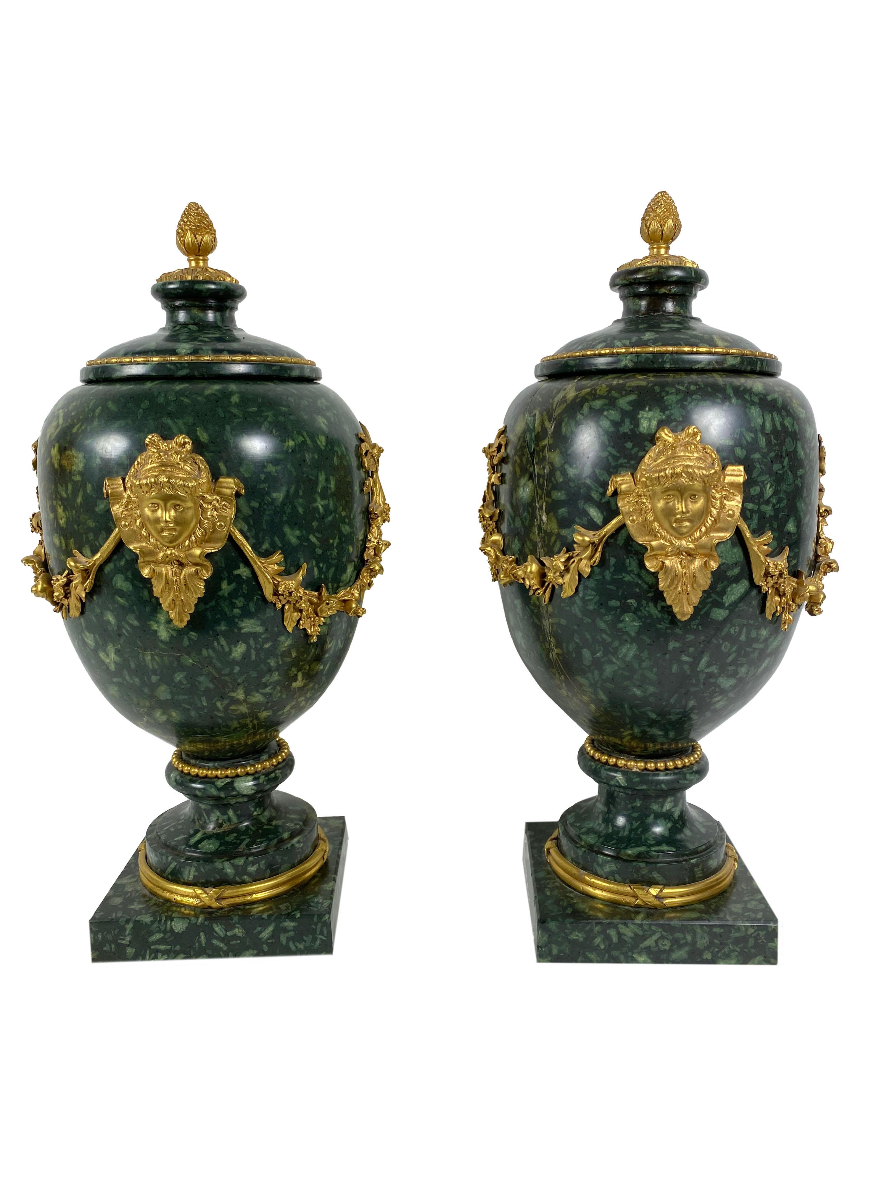 18th century Italian Porphyry stone with 19th century bronze dore mounts with faces and swags that are attached with square screws. French Louis XV style. The vases are with lids, four pieces total.