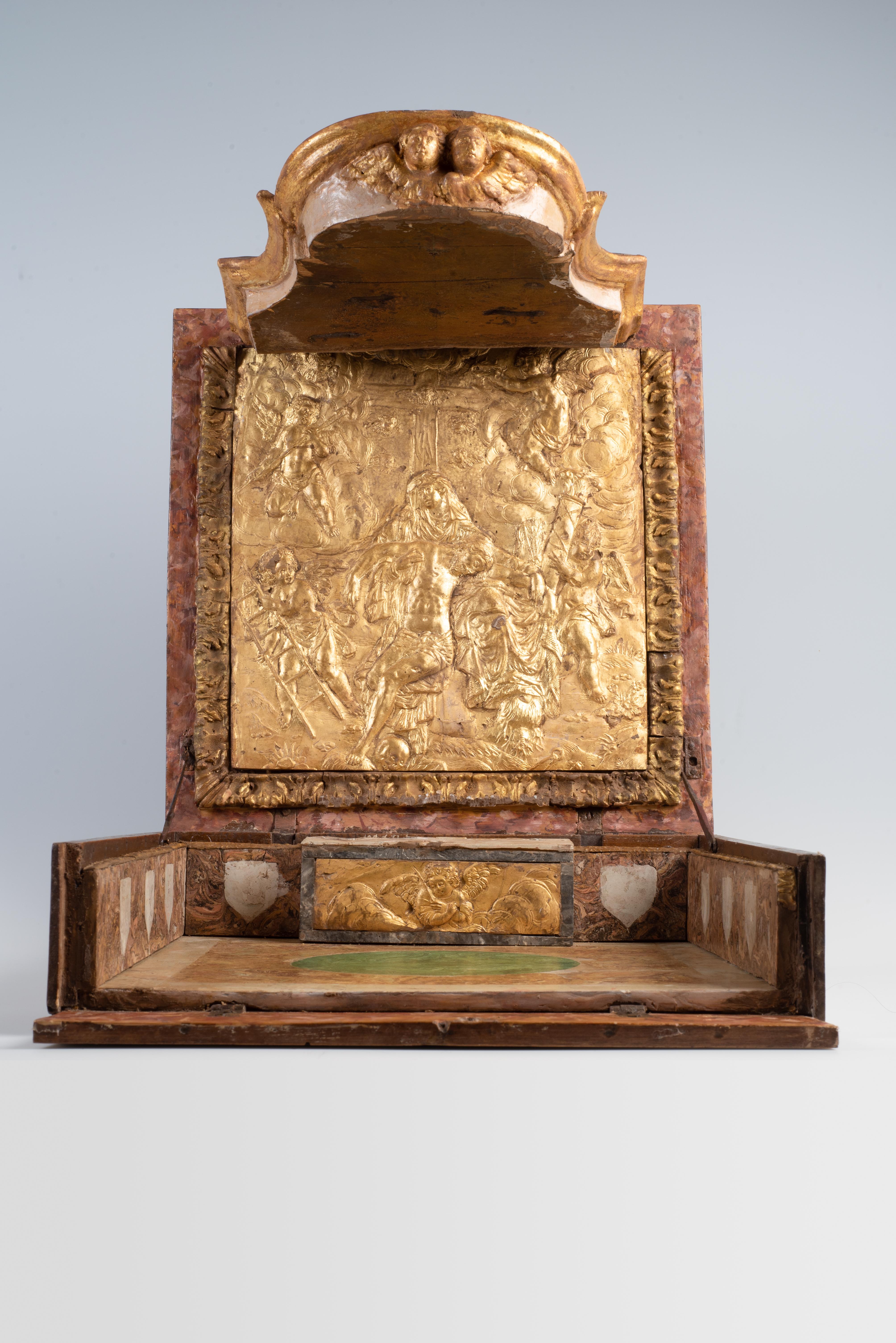 Autel de voyage portatif italien, C.I.C., 1730.
Coffret en noyer avec cartapesta, scagliola et bois sculpté, complet avec accessoires d'origine.

Cet autel rare et magnifiquement conservé date d'environ 1730. La pièce est logée dans un coffret