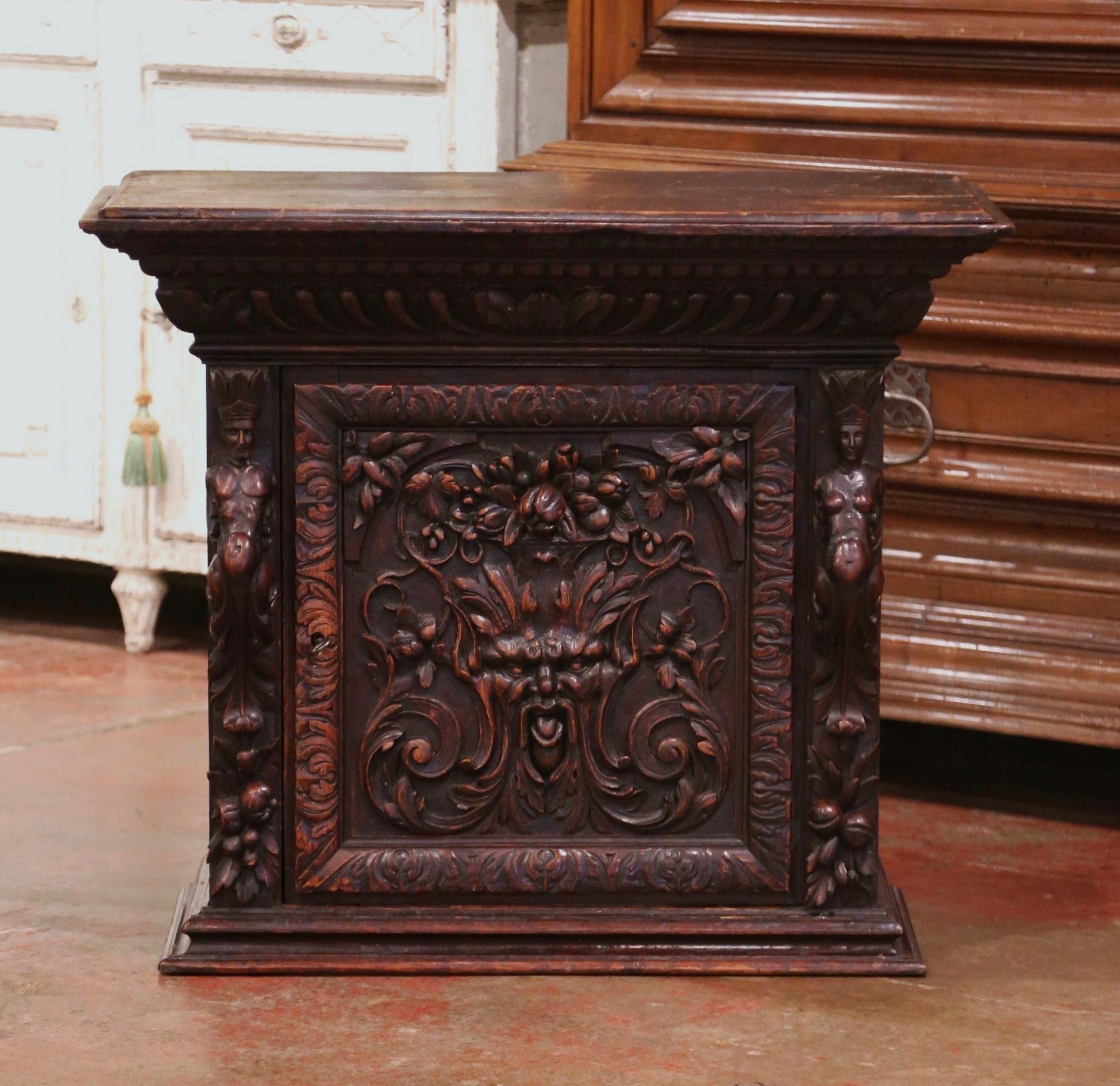 Crafted in Italy circa 1780, the cabinet is heavily carved with figure and floral motif. It features a central door opening to inside shelving. The Gothic style cabinet is in excellent condition with a rich walnut patina. Hooks in the back for easy