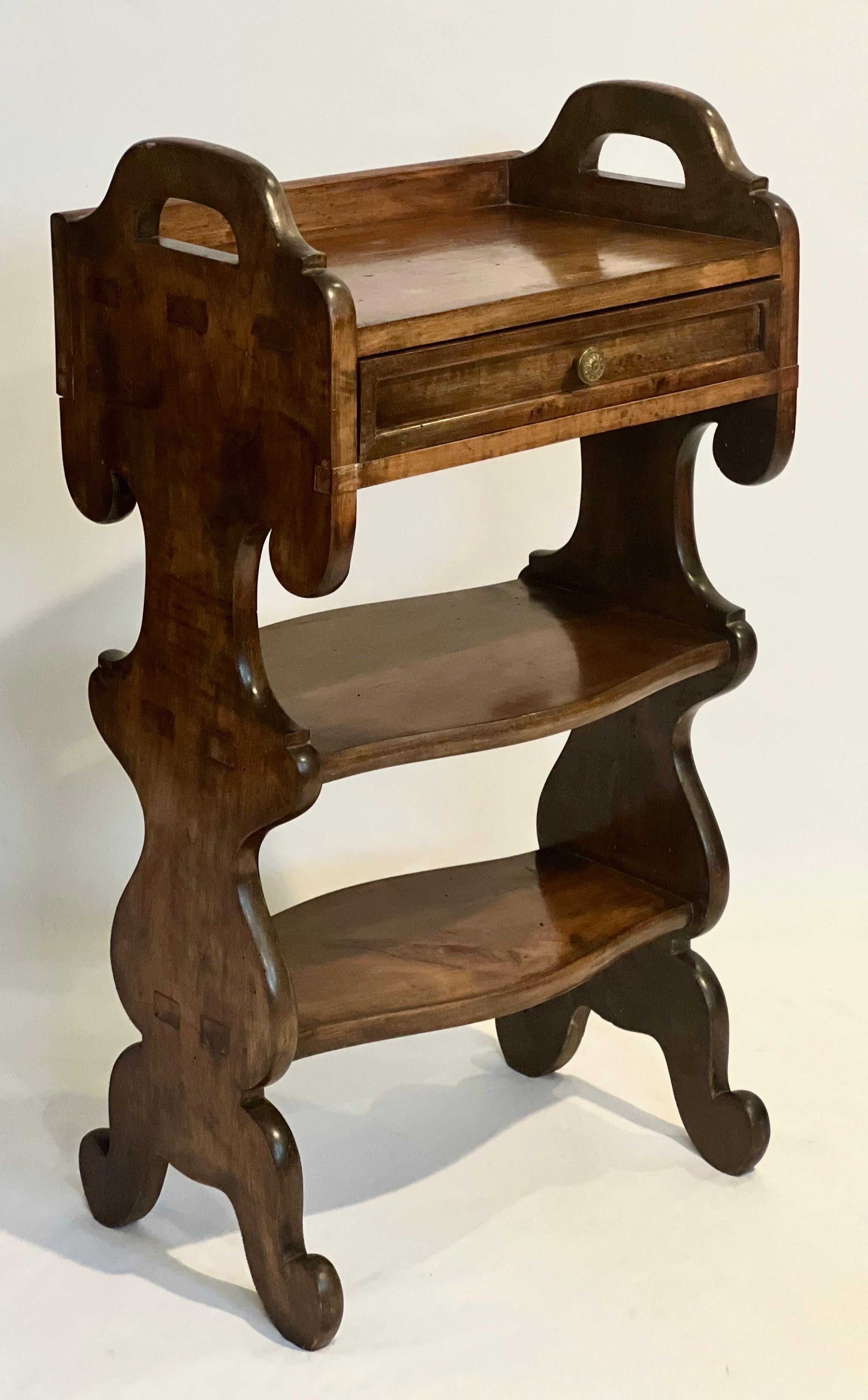 Unique Italian Renaissance style etagere stand, c. late 18th century.

A masterfully crafted stand of figured walnut featuring a single paneled drawer with a finished interior and two shelves between Renaissance style end supports. A beautifully
