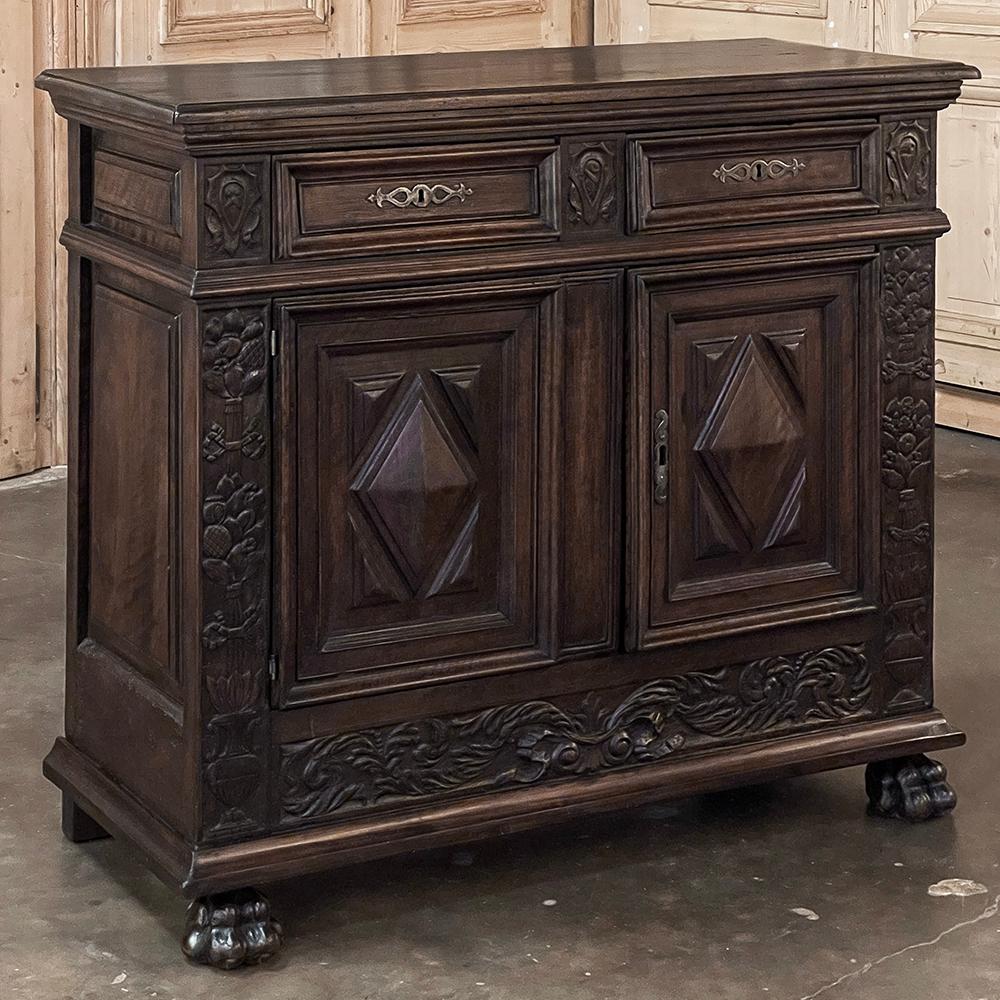 18th Century Italian Renaissance Walnut Buffet is a fascinating combination of Renaissance-inspired carved detail contrasting with pyramidal forms appearing on each cabinet door.  Hand-sculpted from solid Italian walnut, it is of relatively