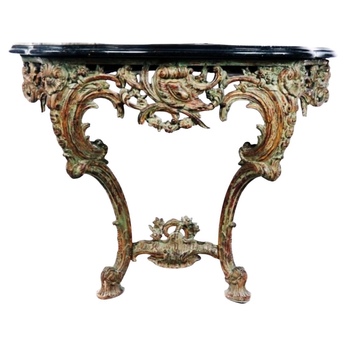 Beautifully carved Italian, likely Venice, 18th century Rococo console table with black Limestone top. The wonderful asymmetrical undulating forms that are carved are reminiscent of the tides and waves of the sea. Only to be accompanied by images of