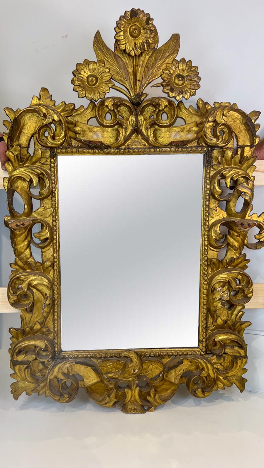 A beautiful, ornately carved mirror. The top-most ornament is a large sunflower.