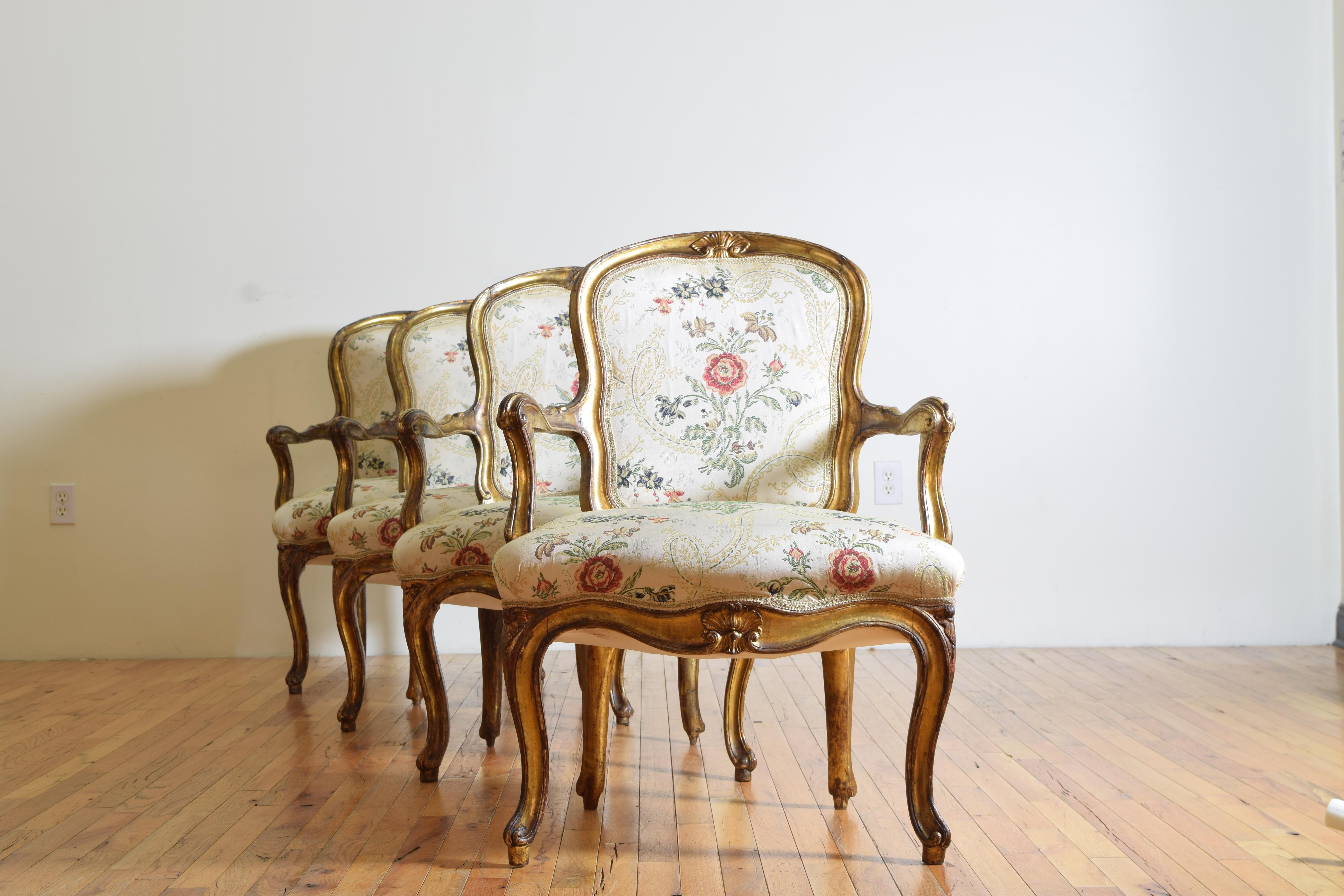 Ensemble de quatre fauteuils de style rococo, d'époque Louis XV, en bois sculpté et doré, reposant sur des pieds cabriole. La façade courbée en forme de serpentin est ornée d'une coquille sculptée en son centre. Le style est curviligne, moins rigide