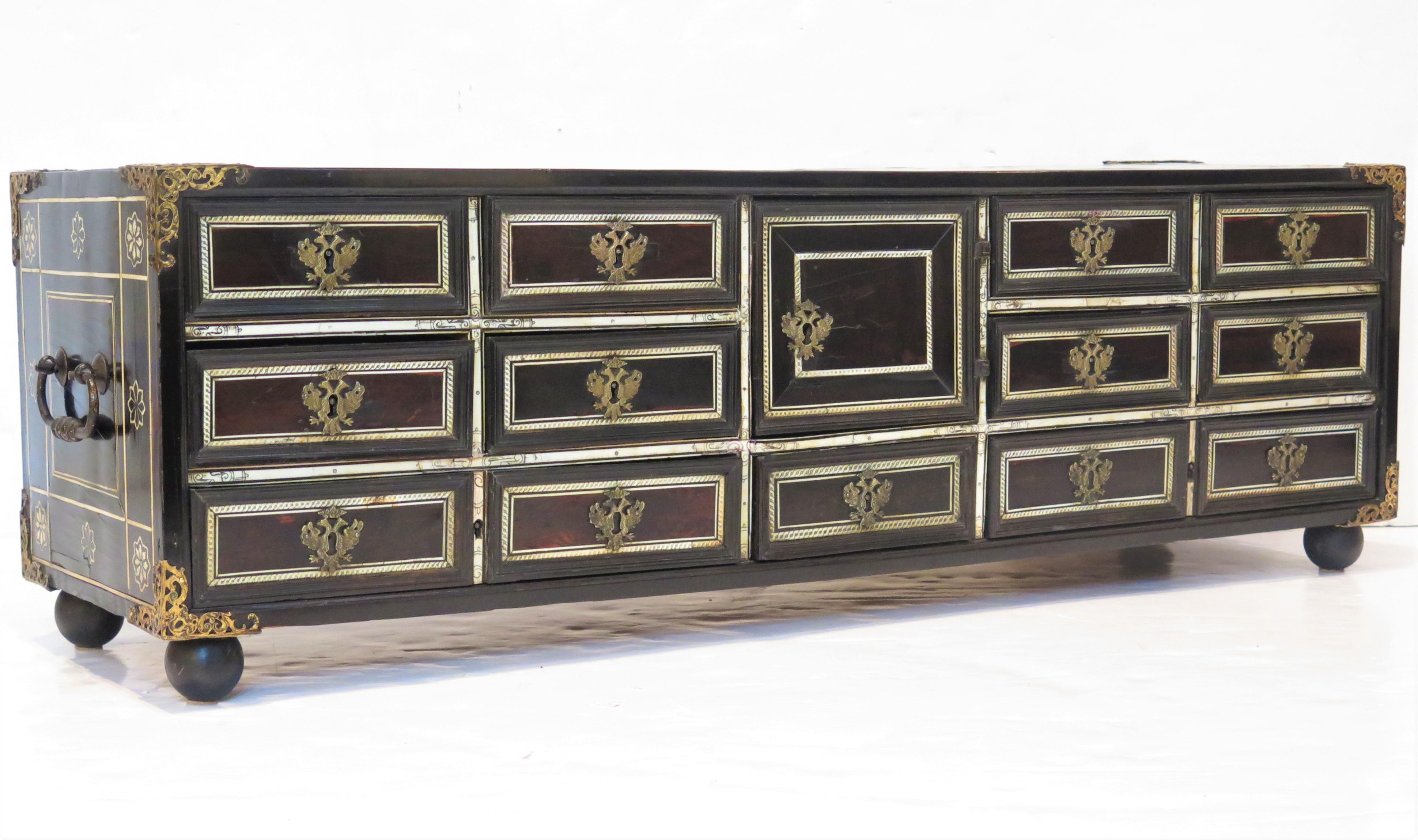 an Italian rosewood table cabinet (vargueño or papelera) with brass ornaments and inlaid incised bone decoration, there are eleven drawers (two bottom drawers are double width and appear to be four drawers) and one central cabinet door, it is
