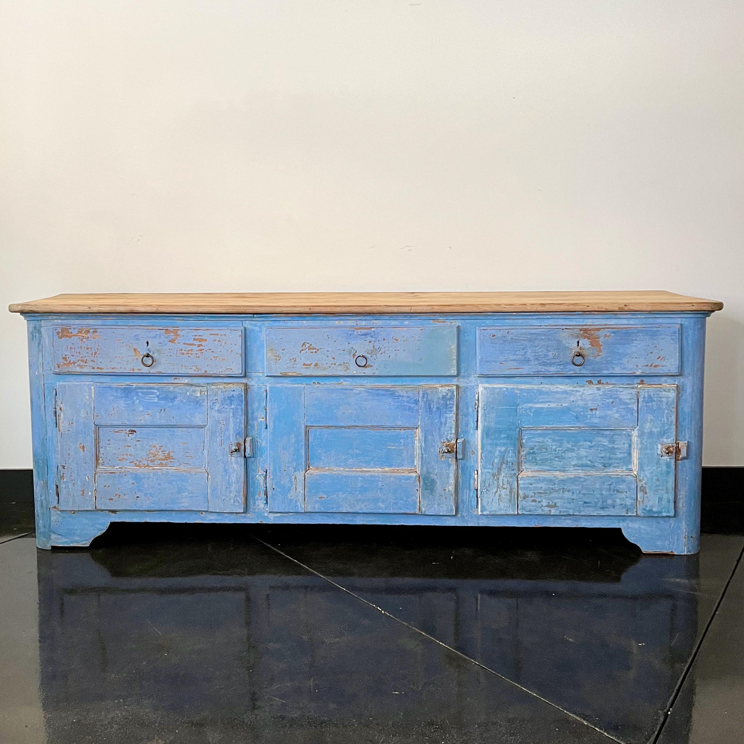 A long, very patinated with original brilliant blue color Italian 18th century rustic sideboard with three paneled large doors and drawers under natural rounded shape blank top.
More than ever, we selected the best, the rarest, the unusual, the