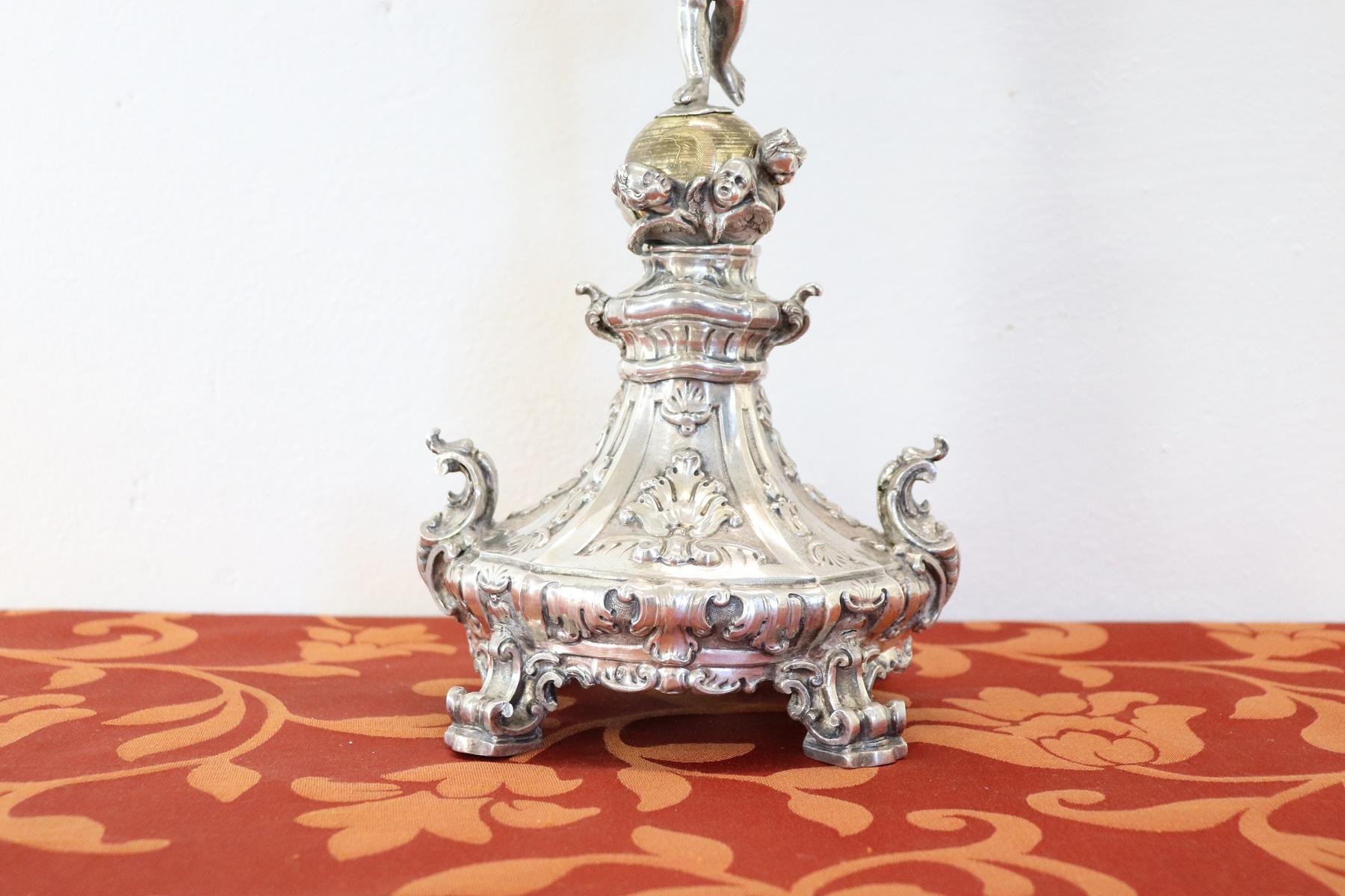 Important Sicilian monstrance in embossed and chiselled silver.
characterized by a candlestick base with four curled feet, from which, on a starry globe, resting on a foot, a winged putto supporting the door - relics surrounded by a radial