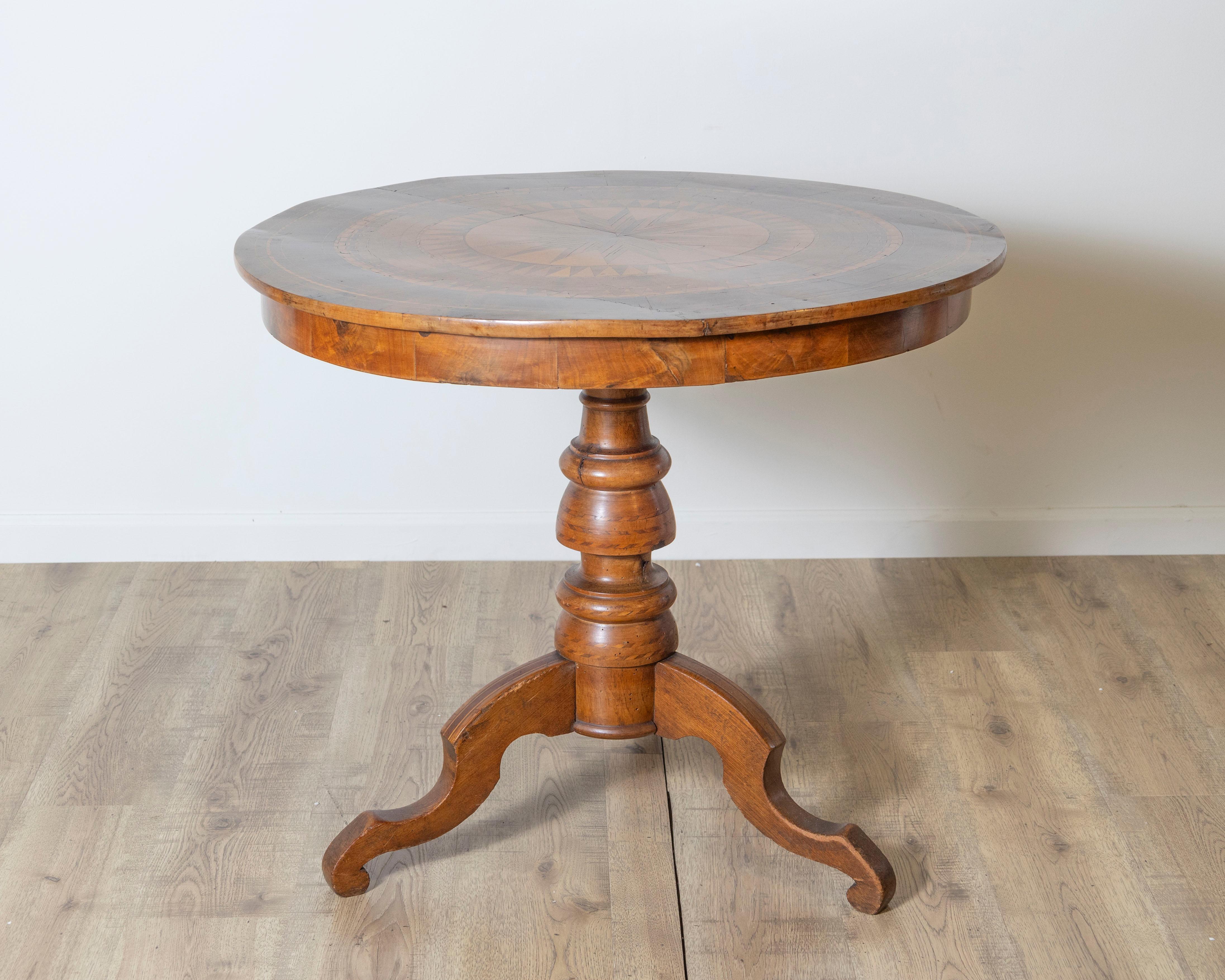 Remarquable table centrale italienne de Sorrente du XVIIIe siècle, dotée d'un plateau délicieusement incrusté de diverses essences de bois. La surface circulaire est richement décorée d'un motif géométrique en forme d'étoile, rayonnant à partir du
