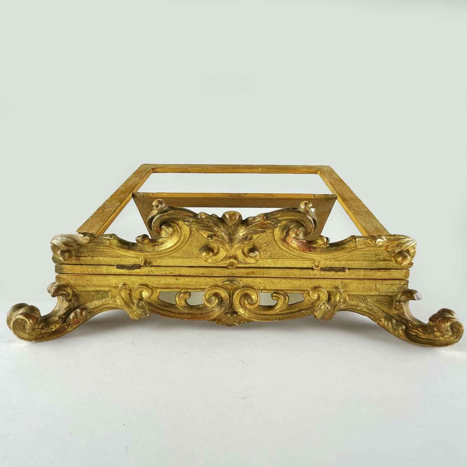 From Italy, a late 18th century carved and gilded table lectern, an antique rectangular spruce wood bookstand or music stand on four curling feet. This antique reading bookstand is adjustable and the turning support allowing the lectern to be placed