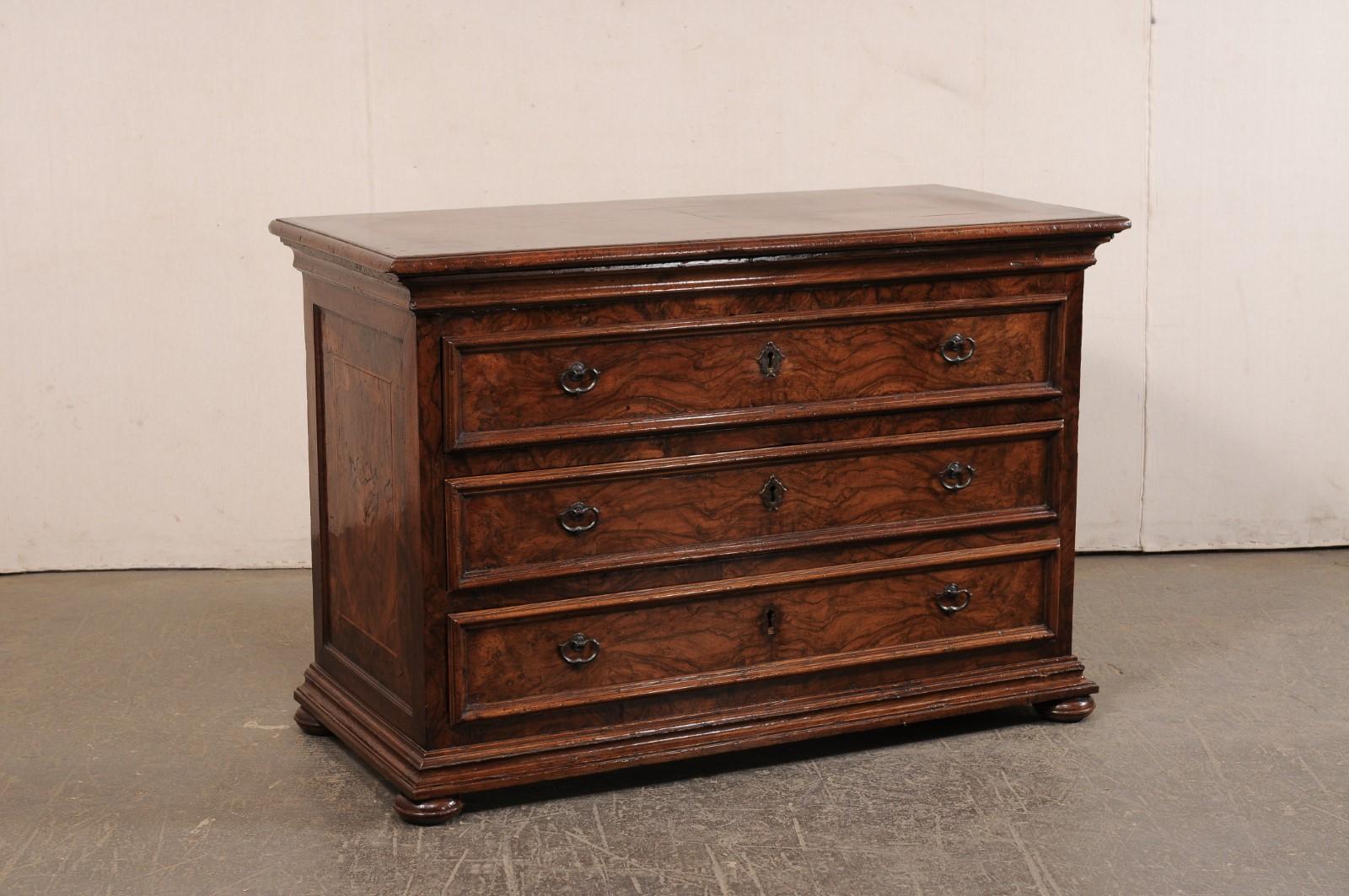 An Italian burl wood veneered chest of drawers from the 18th century. This antique chest from Italy has a rectangular-shaped top with burled veneer and a decorative banding inlay, which rests atop a case that houses three full-sized, dovetailed,