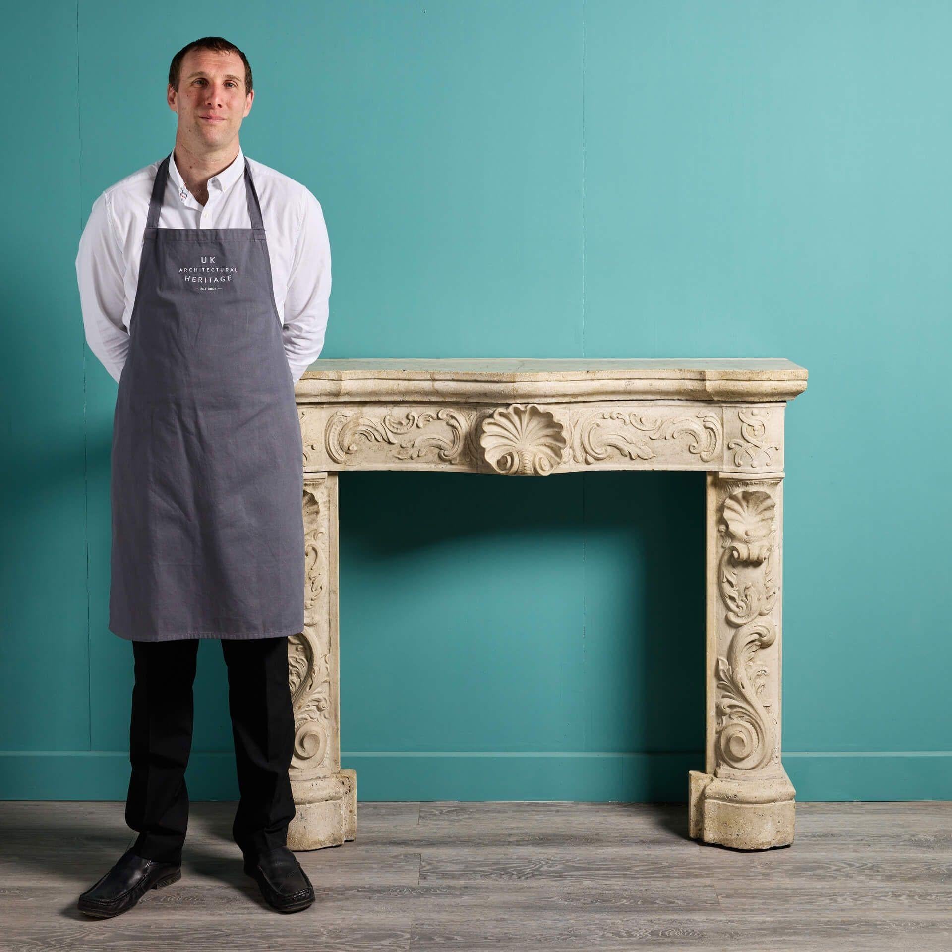 This very early 18th century Italian travertine marble fireplace was sourced from a property in Kensington and removed during remodelling. It features an elaborate design, the frieze and jambs beautifully embellished with carved scrolls and clam