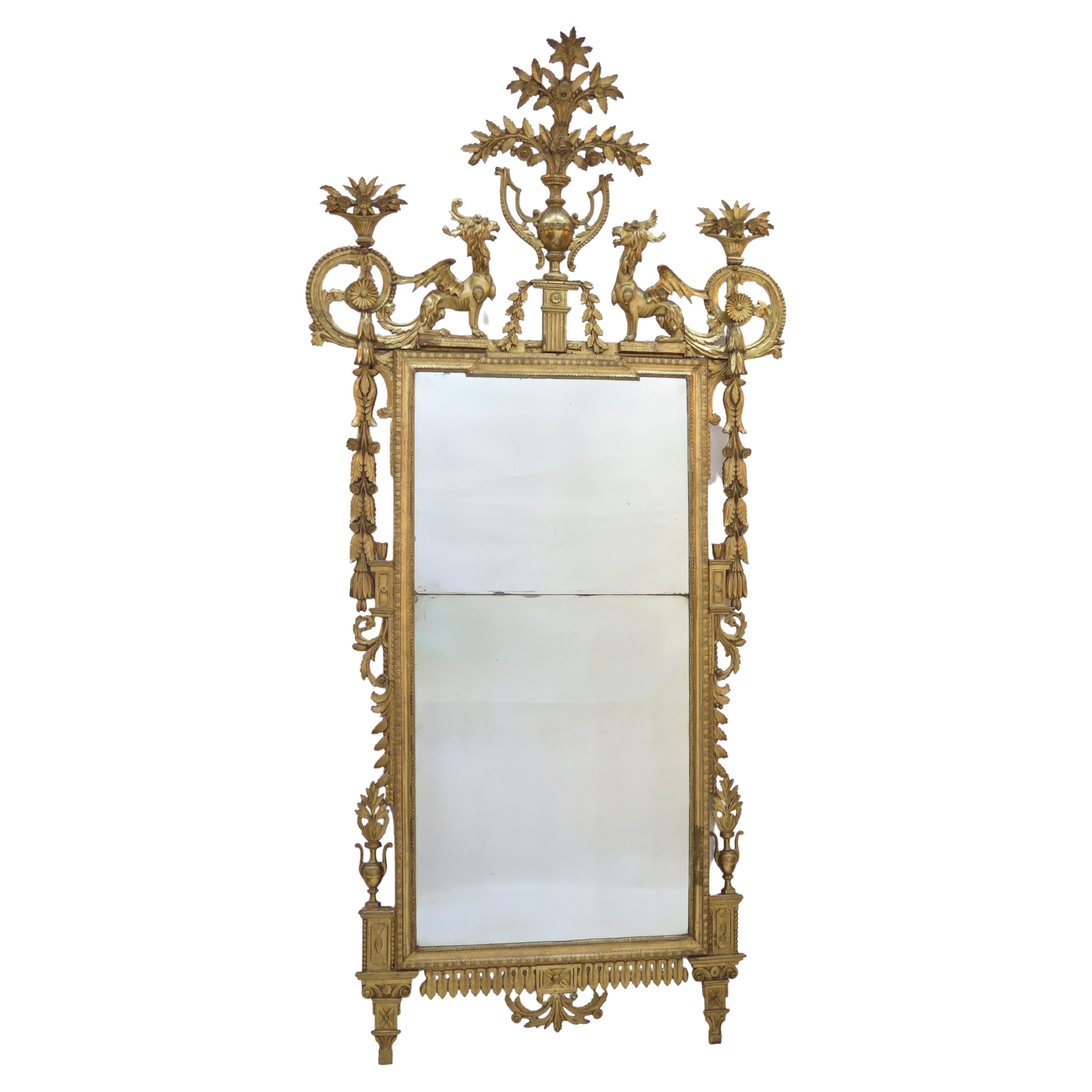 espejo neoclásico italiano de madera dorada del siglo XVIII con una gran urna central con ramos de flores, flanqueada por bestias aladas, motivos foliados tallados por todas partes, molduras, placas de espejo planas y seccionadas, patas cónicas,