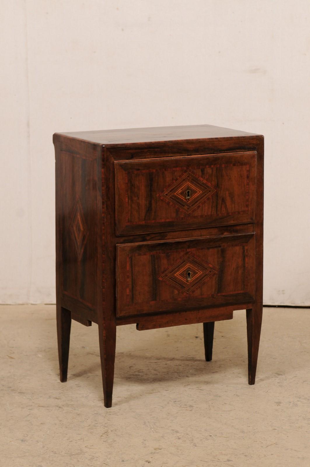 An Italian two-drawer raised side chest, with nice decorative inlay, from the 18th century. This antique side chest or end-table from Italy is adorn with beautiful inlay patterning throughout, and features stylized diamond motif at it's top, side,