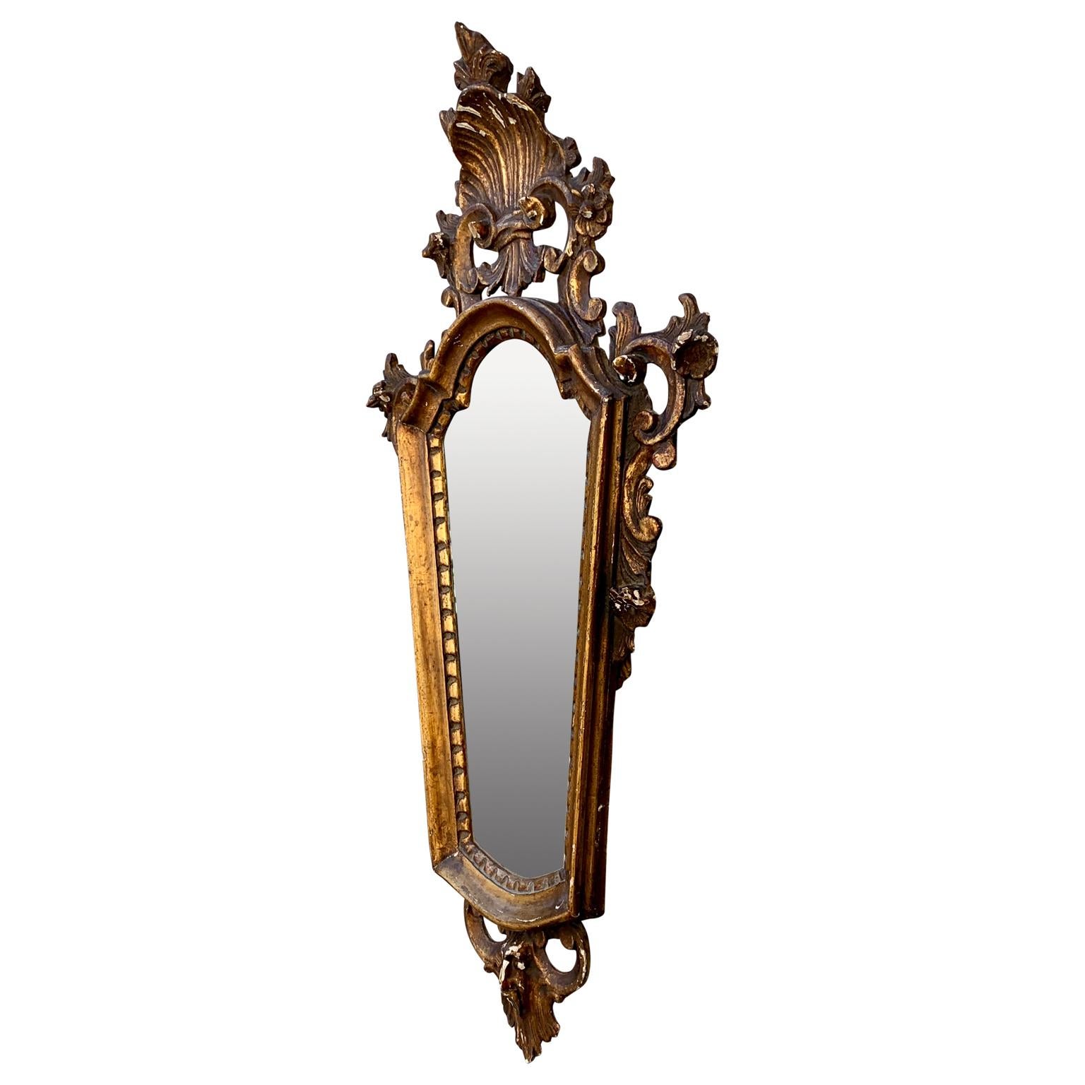 An 18th Century Italian Rococo wall mirror from Venice, Italy.
This Venetian Rococo mirror has its original mirror-glass and backing, which is quite amazing since this Italian wall decoration is almost 300 years old.
The wooden frame displays a rich