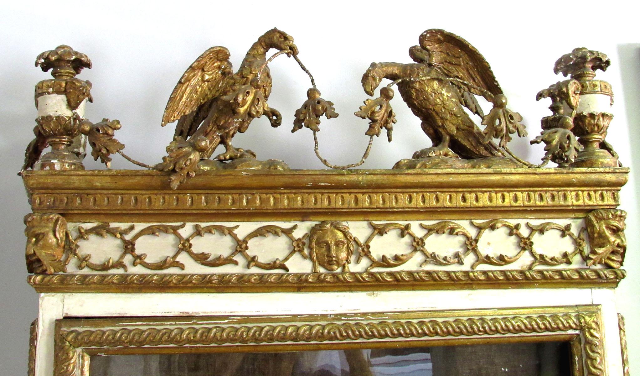 Very fine and rare 18th Century Italian Vitrine of hand-carved painted and parcel gilt wood, with facing eagles  and urns adorning the crown, masks and gadrooning above the door and side panels supporting old wavy bubble glass, all raised on shaped