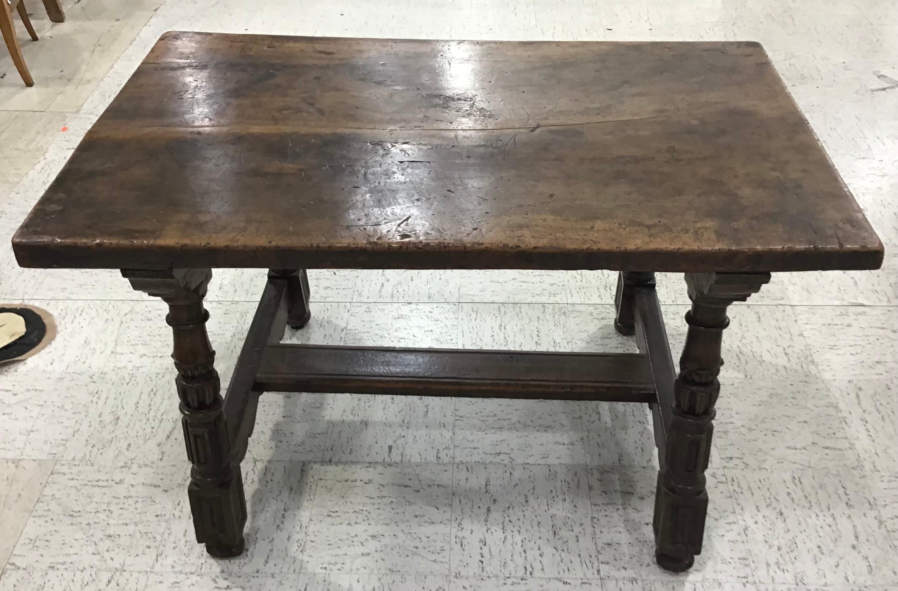 Italian, 18th century. Baroque walnut dining or tavern table having a thick walnut top above turned legs with Walnut stretcher. Perfect size to use as a writing table, sofa or center table.
