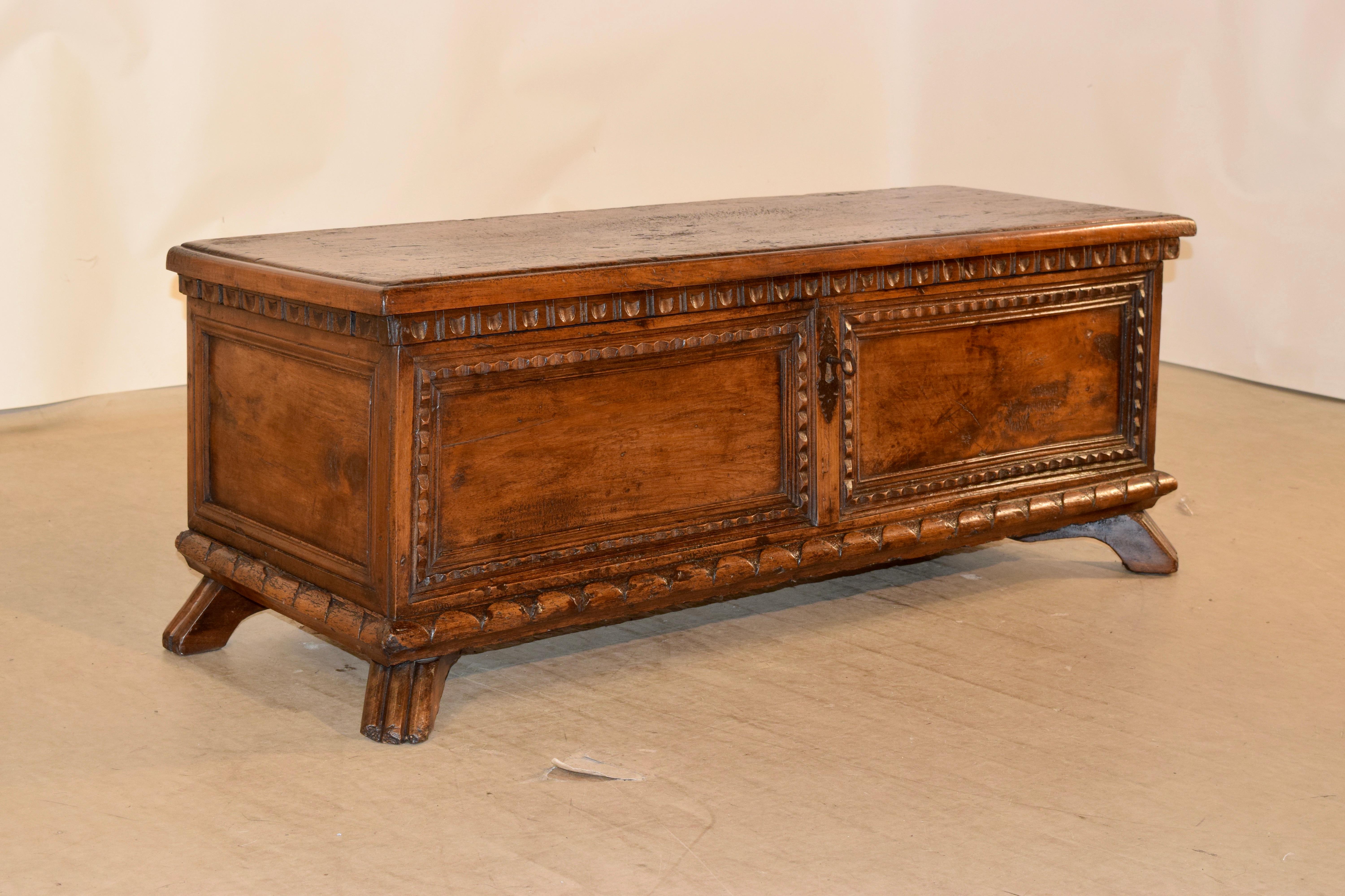 18th century Italian cassone hand carved out of walnut. The top is plain with a beveled edge and the sides are also plain with molded panels. The front panel has linear molding which form two rectangular panels. The case rests upon four rustic hand
