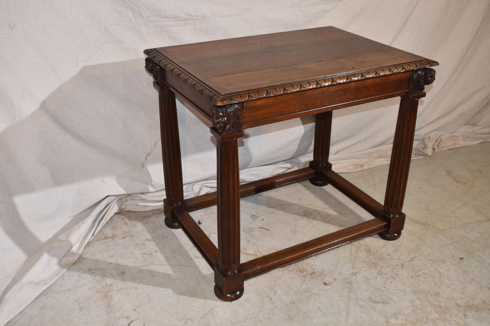 A beautiful solid walnut Italian center table from the late 18th century. The paneled walnut top is resting on a carved apron with fluted column legs. All ending on a pegged box stretcher with bun feet. The table features a dovetailed drawer to the