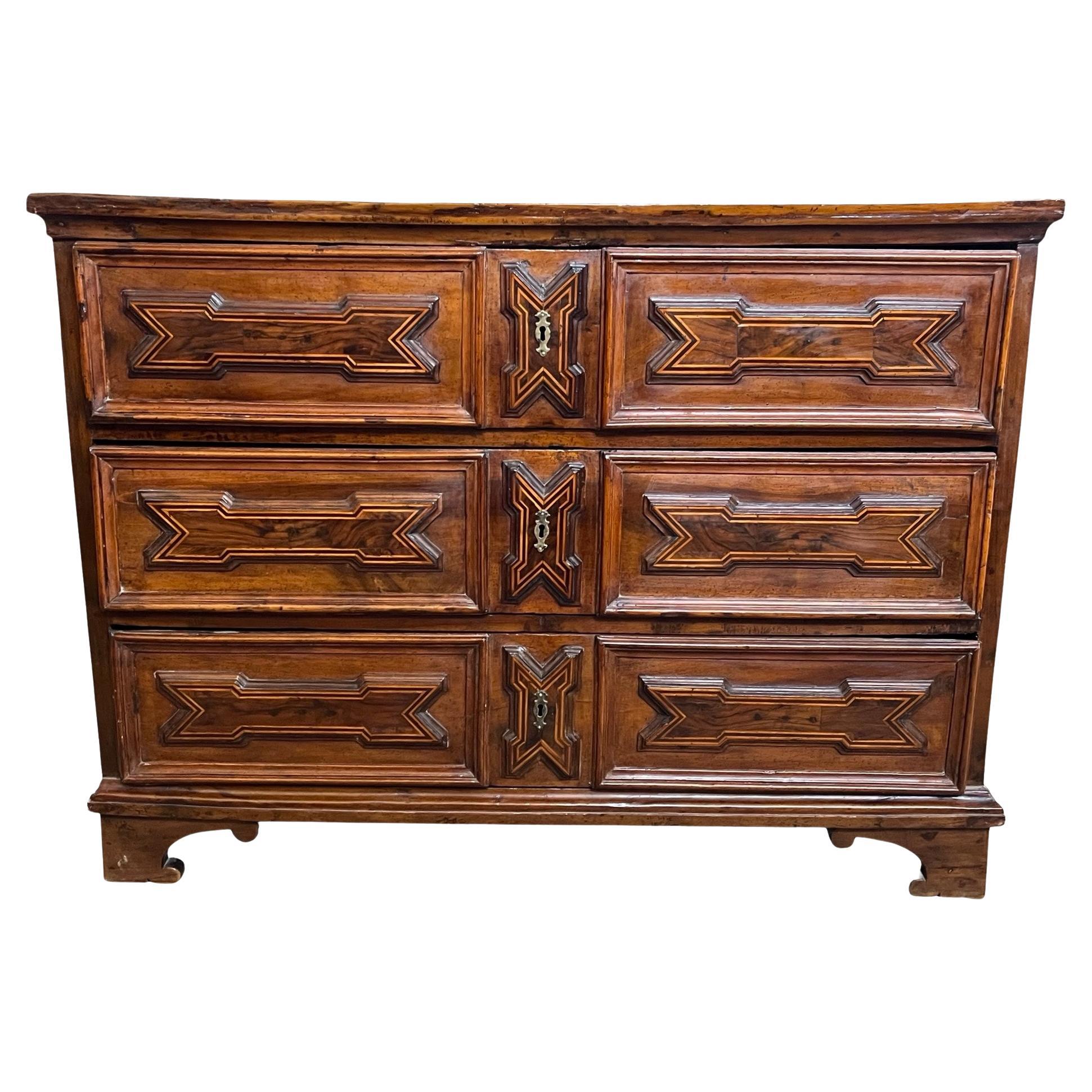 Commodo realizzato a mano nel centro Italia all'inizio del 1700 con legno di noce e decorato con intarsi in noce e legno di frutta. La commode presenta tre cassetti incassati, tutti con splendidi incastri a coda di rondine fatti a mano, e decorati