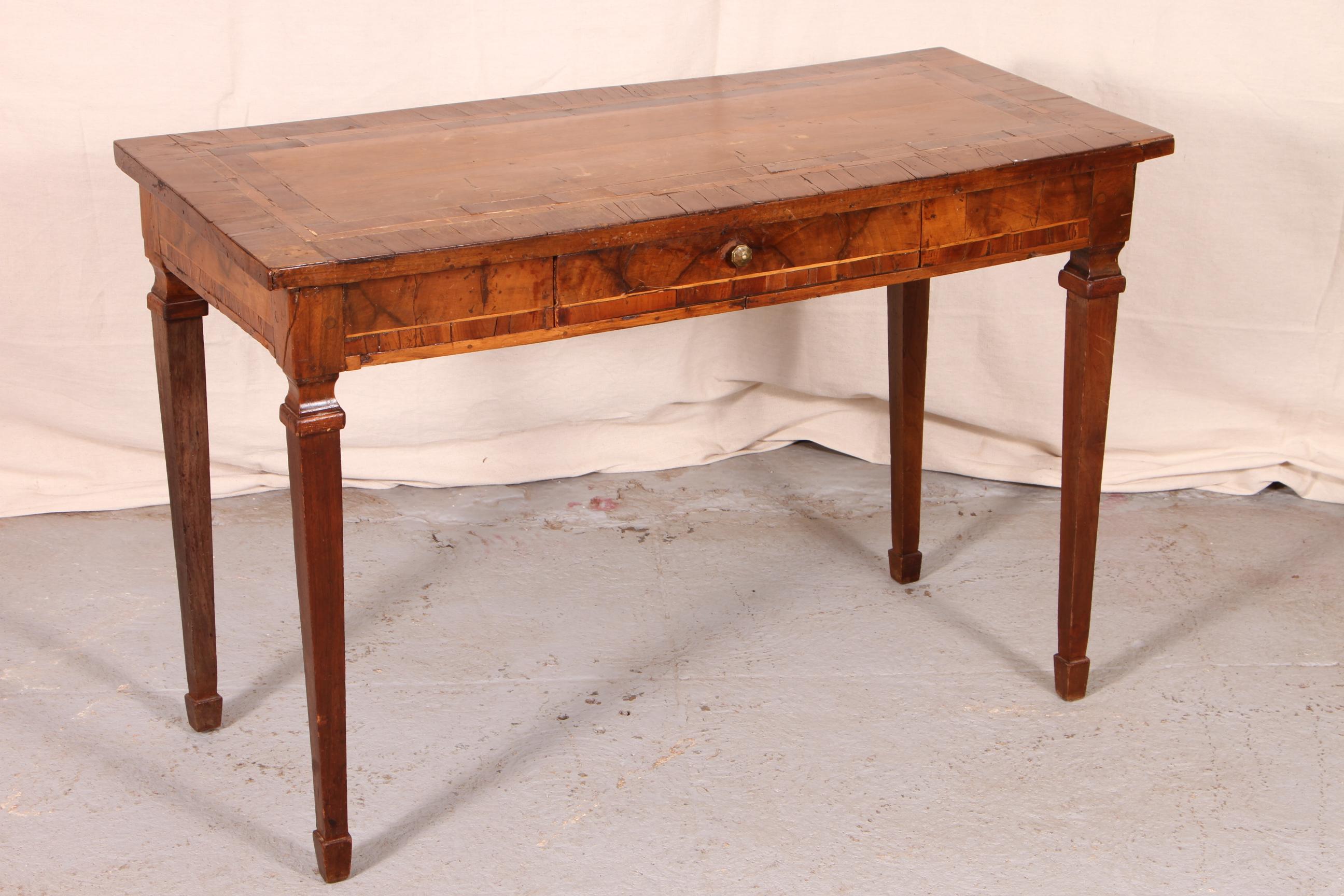 18th century Italian console, walnut, rectangular with a double banded top, the burled frieze banded in walnut with a single drawer on the front, and raised on tall square tapering legs with spade feet. 

Condition: Checking and cracks to banding