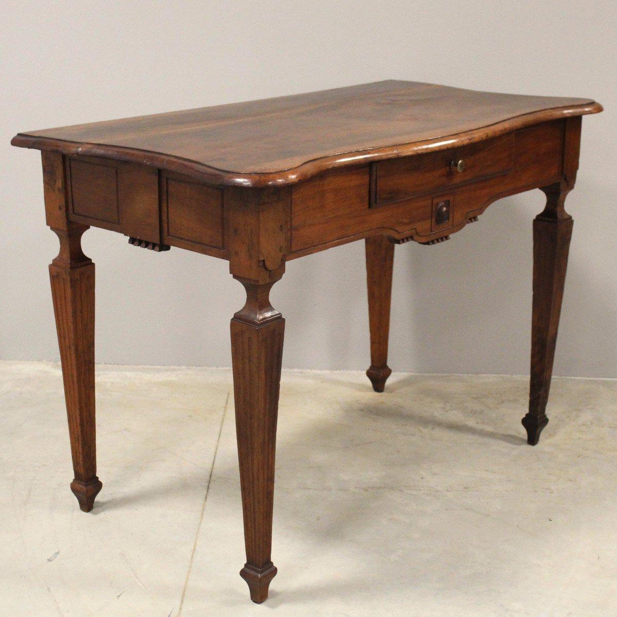 An Italian walnut console table from the 18th century with serpentine top, single drawer, carved apron and tapered legs. Emanate the grandeur of 18th-century Italian artistry with this sumptuous walnut console table. The eye is instantly drawn to