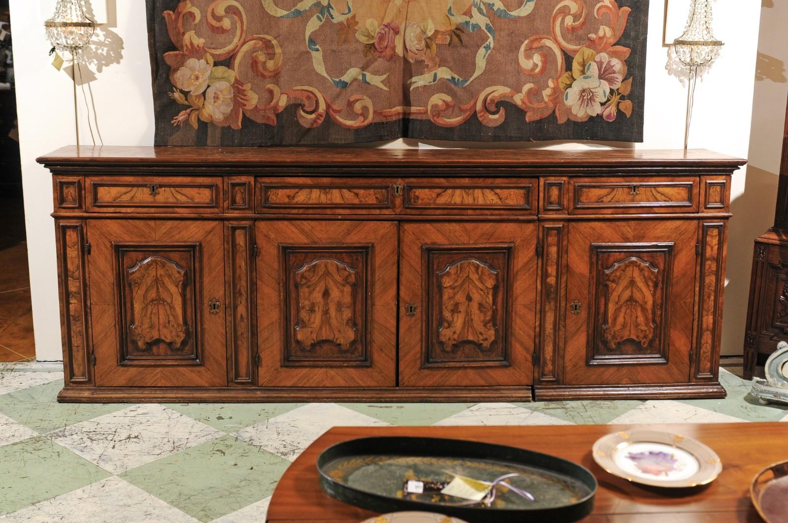 The 18th century walnut Italian credenza of long shallow size with 3 burled walnut over 4 burled walnut raised paneled cabinet doors. 

