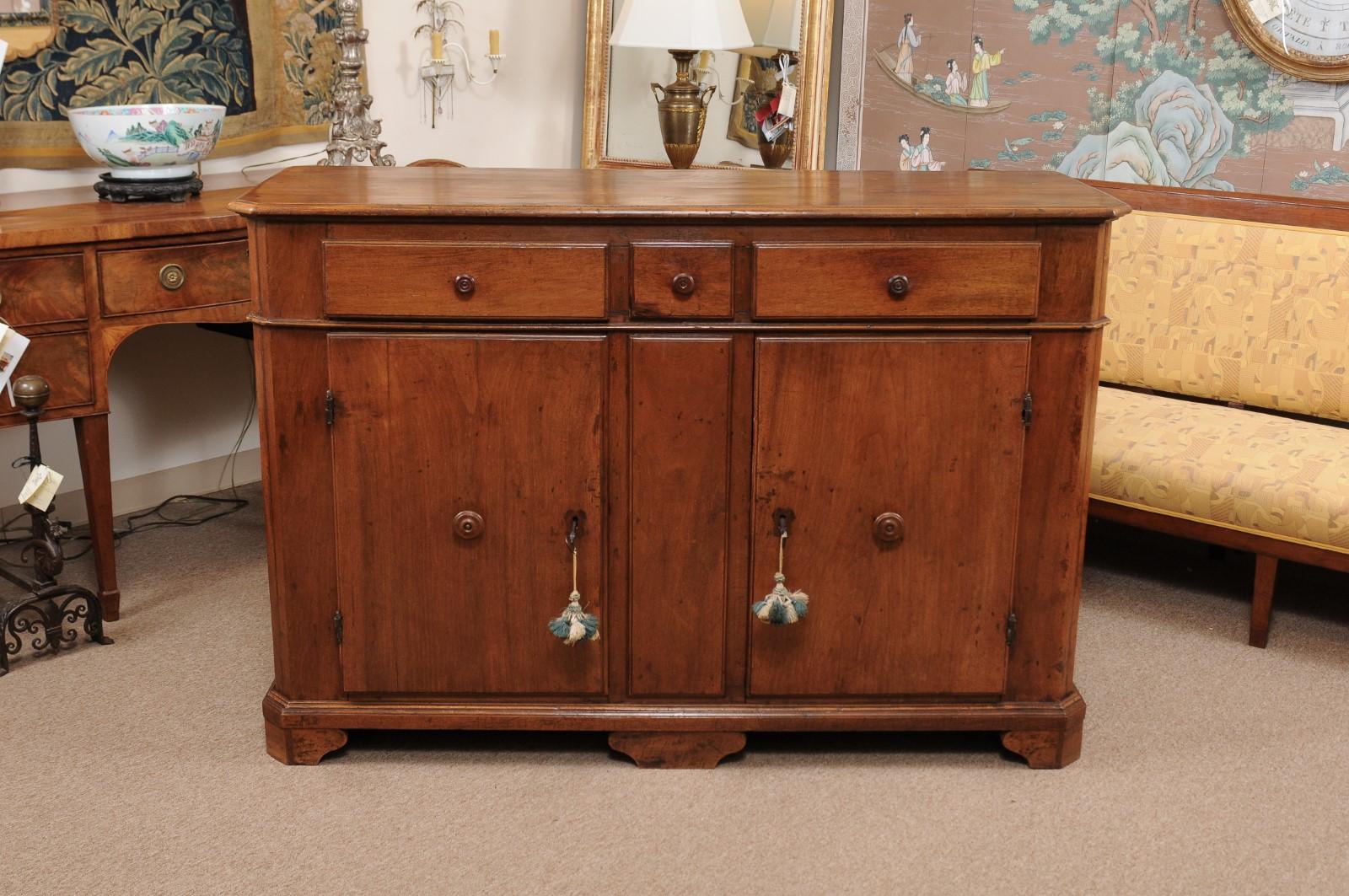 A 18th century Italian walnut credenza with canted sides, 3 drawers and 2 door cabinet below.

 