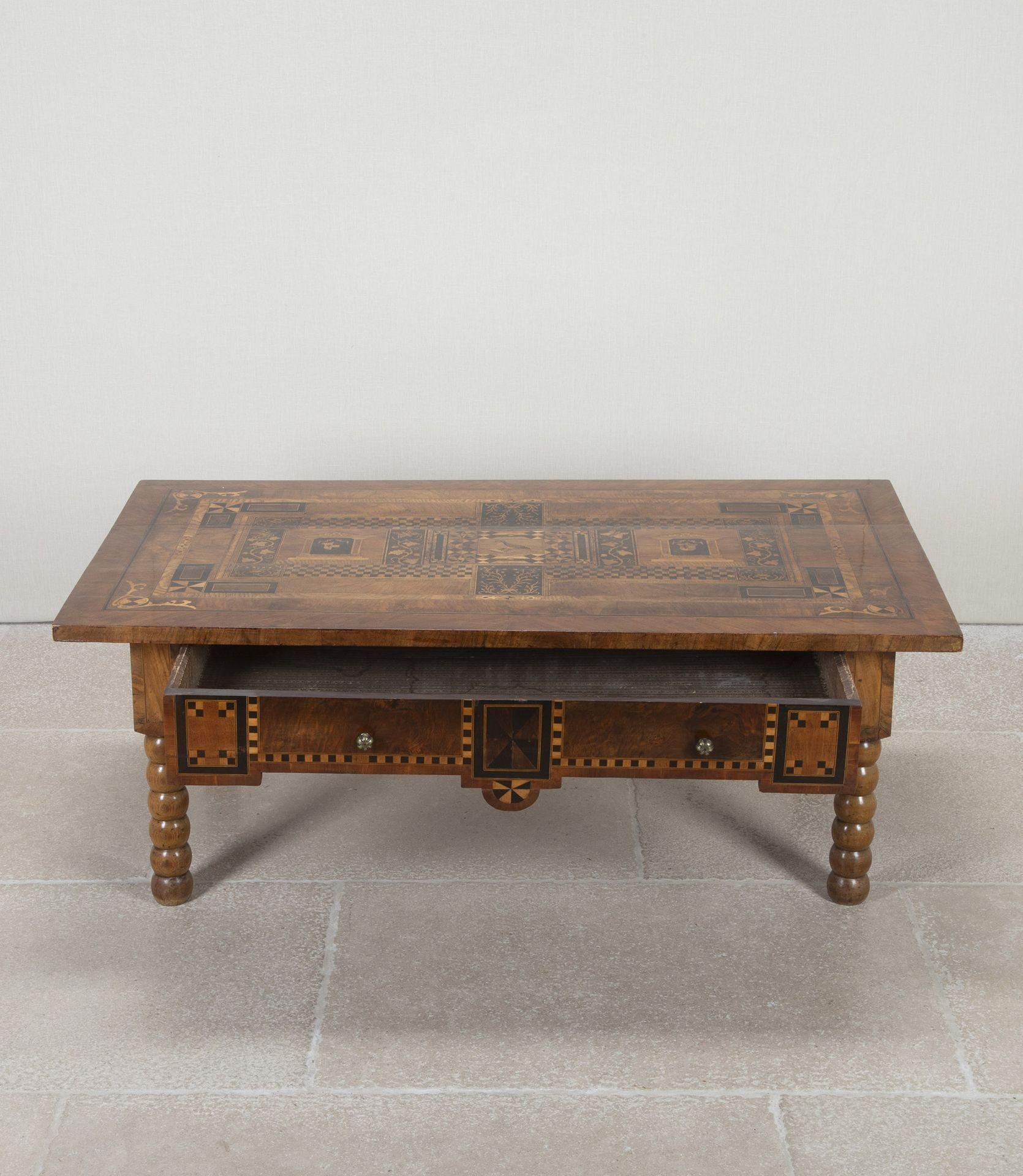 Mesa baja o de café italiana de nogal del siglo XVIII.
Con tablero de marquetería y cajón friso en toda su longitud. Descansa sobre una base de nogal de finales del siglo XIX.