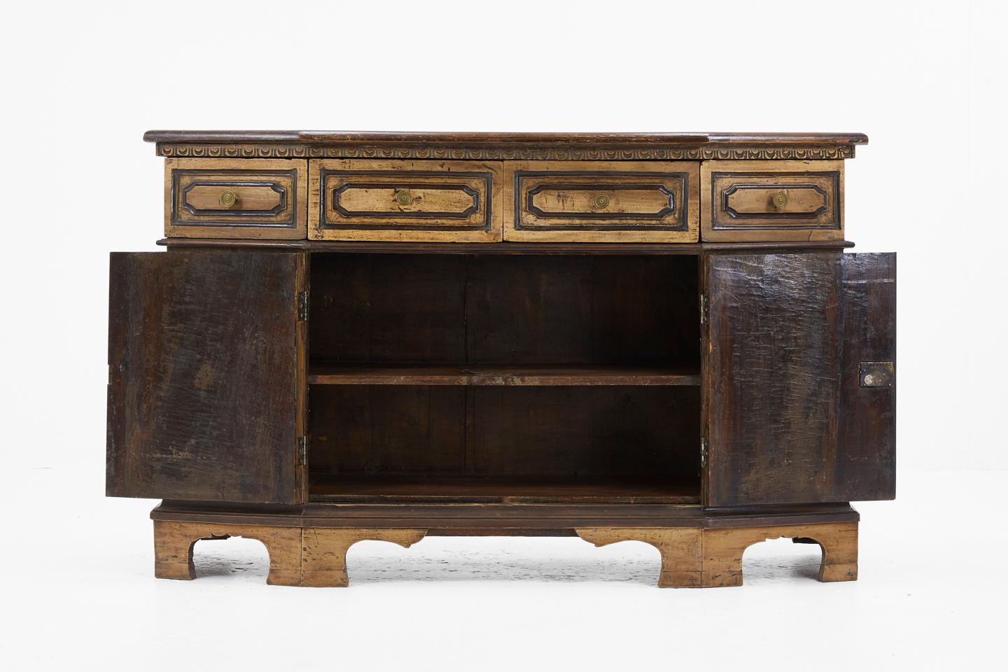 Rustic 18th century Italian walnut sideboard of unusual shape and nice small proportions, with decorative carved panel doors and drawers.