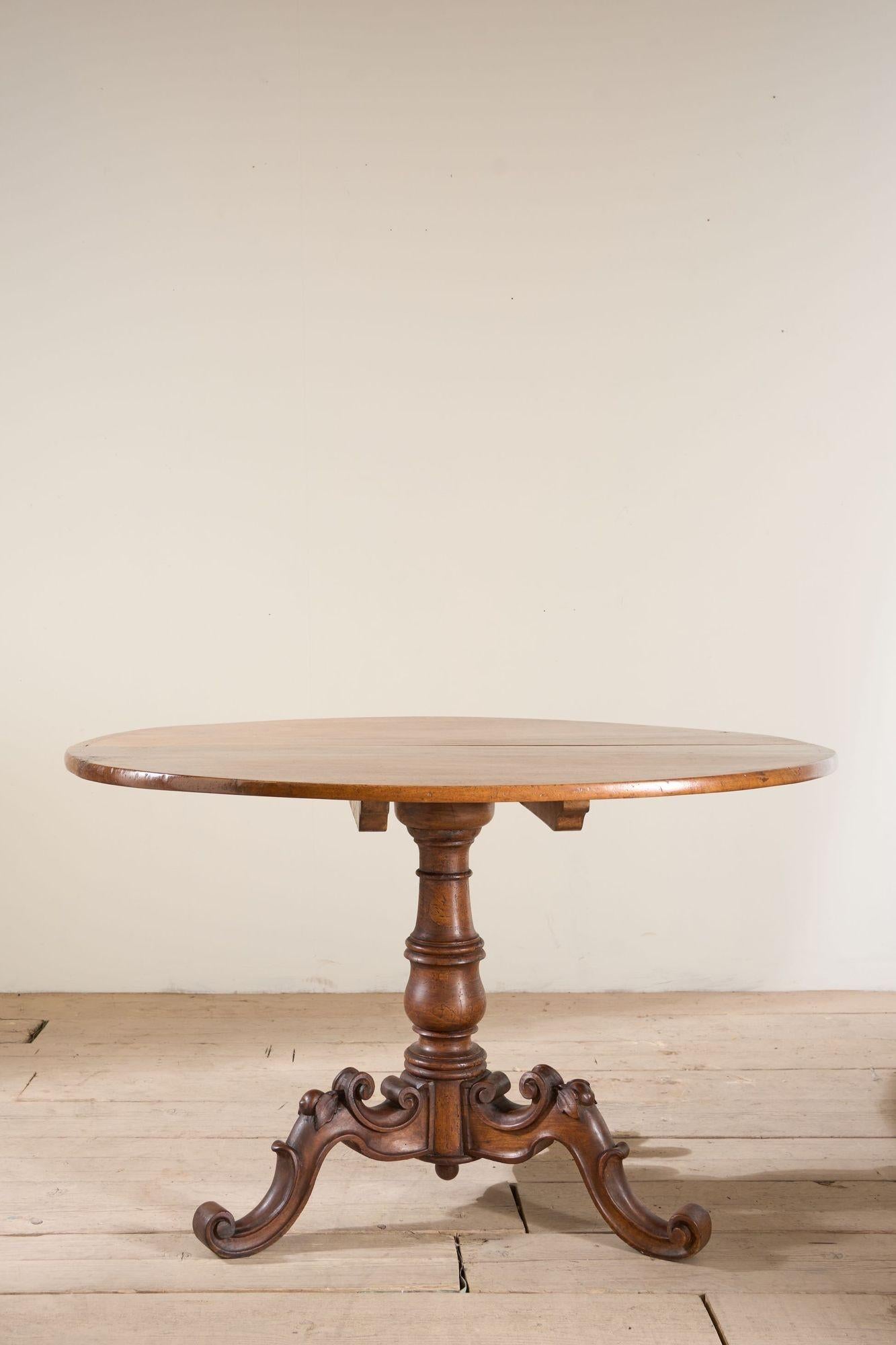 This is an exceptional quality late 18th, early 19th century Italian circular tilt top table. The top is made from solid walnut and is a butterfly cut piece meaning the grain is mirrored which is a stunning detail. The base is well carved with