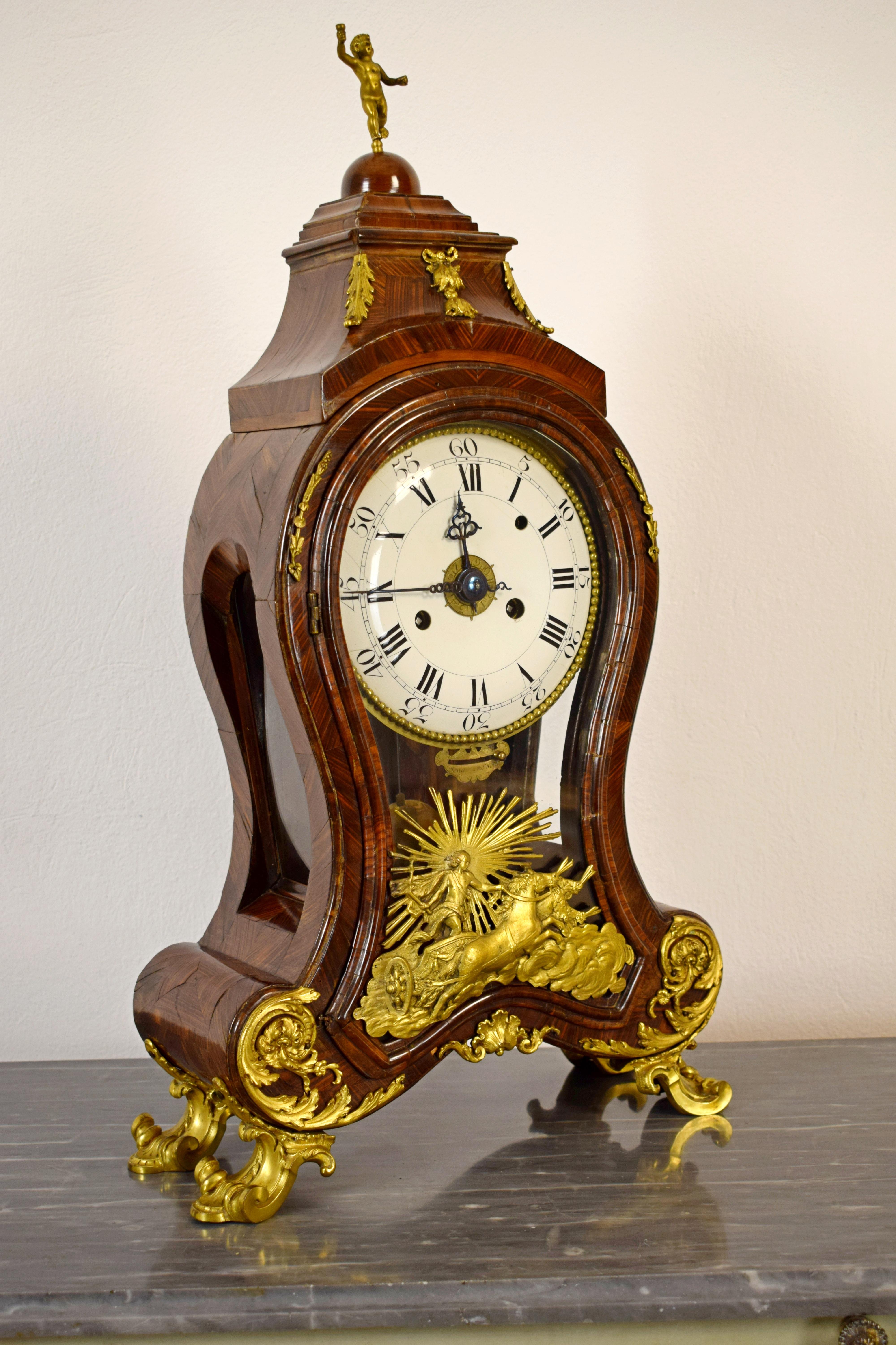 18th century, Italian Louis XV wood ringtone and alarm table clock with gilt bronze

This table clock was made in the north of Italy (Genoa) 18th century, Louis XV era. The case, the sides and the top are paved with fine violet’s wood. The