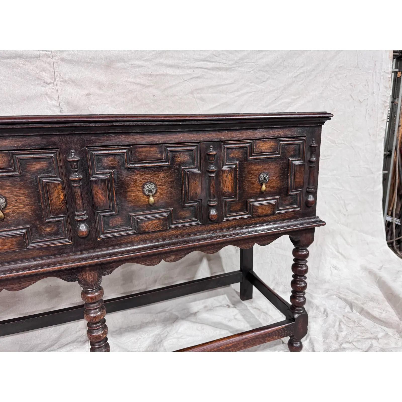 This amazing English server has such an aura of old-world charm about it. It is from the Jacobean period, dating to the 1900s, and has an excellent patina. The server has beautifully done geometric drawer fronts with original pulls, and a wooden
