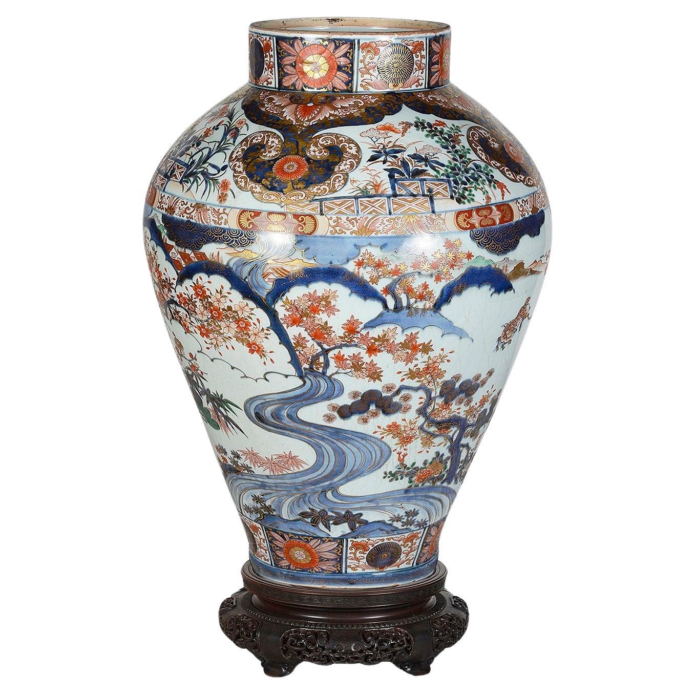 Un spectaculaire vase japonais Arita Imari du 18e siècle sur pied. Il possède de magnifiques couleurs vives. Elle présente un magnifique motif de volutes et une décoration feuillue. Scènes de cerfs se nourrissant sous des arbres en fleurs, avec des