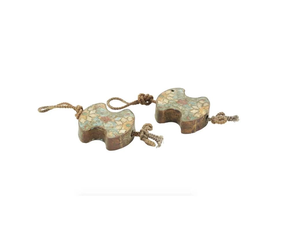 A pair of antique Japanese enamel metal Fuuchin scroll weights. The scroll weights are enameled with polychrome floral and cloud patterns made in the Cloisonne technique. Completed with hanging ropes. A Fuuchin is a pair of weights hung on a