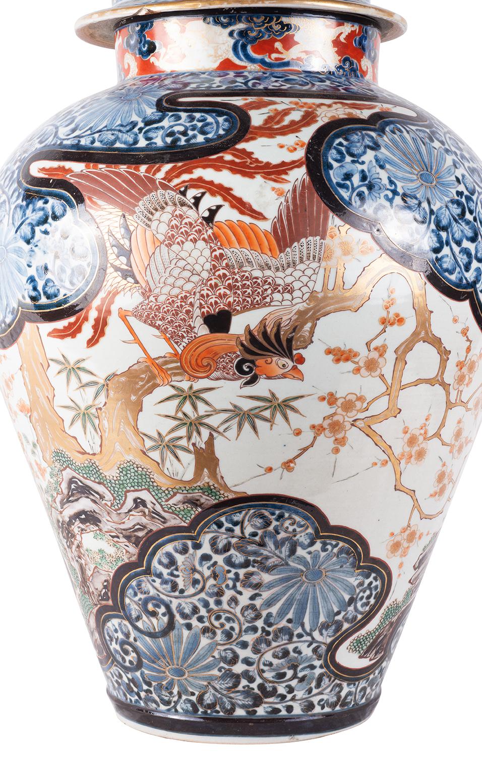 A very impressive 18th century Japanese Imari lidded vase, having a mythical dog of Foo finial to the rounded lid, the classical blue and orange ground, with exotic flowers and scrolling motif decoration. The inset hand painted panel depicting