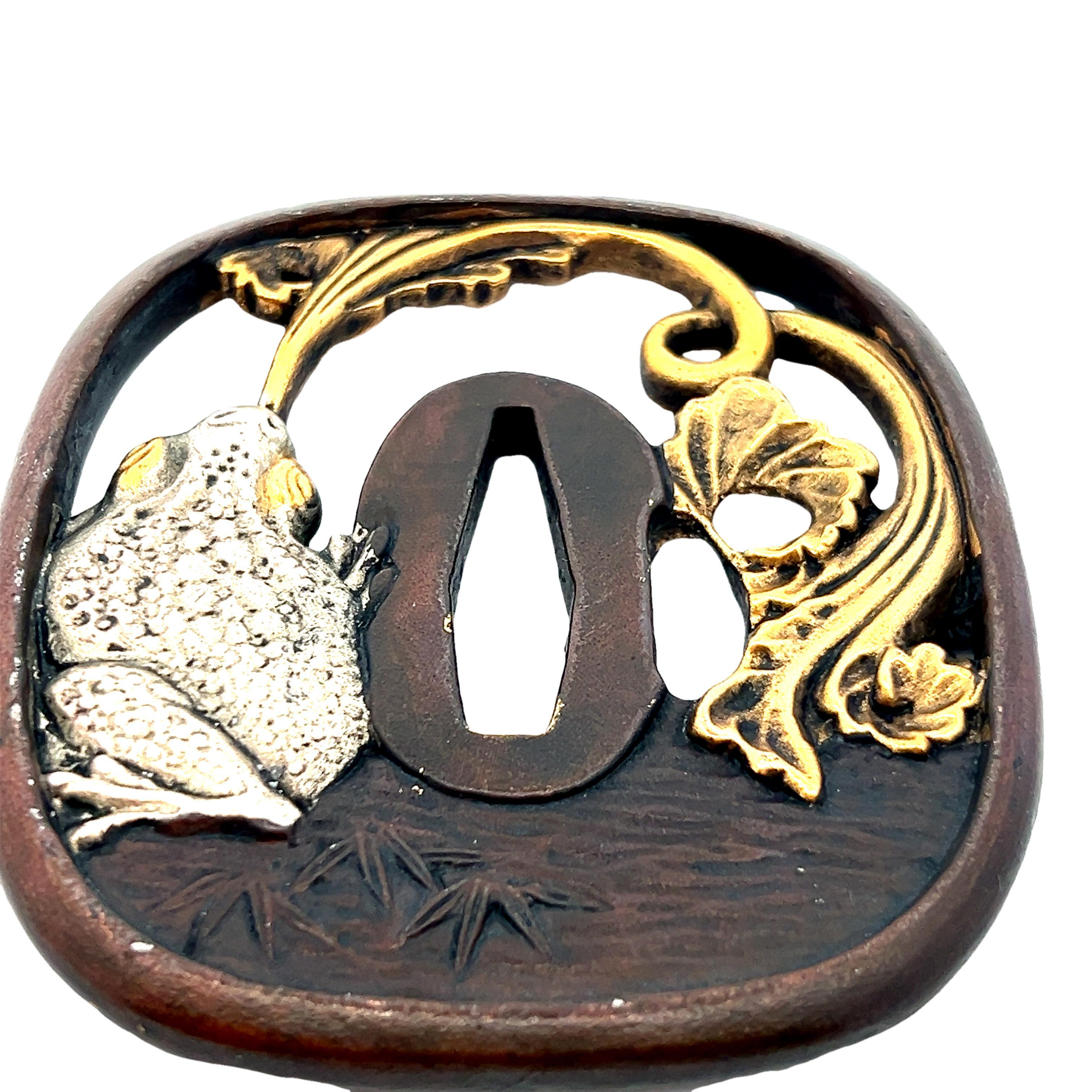 Cette tsuba exceptionnelle est une pièce d'histoire amusante qui provient du Japon du 18e siècle et comprend des décorations en or jaune 18k. La tsuba est le garde-main placé entre la poignée et la lame de l'épée. L'œuvre d'art représente une